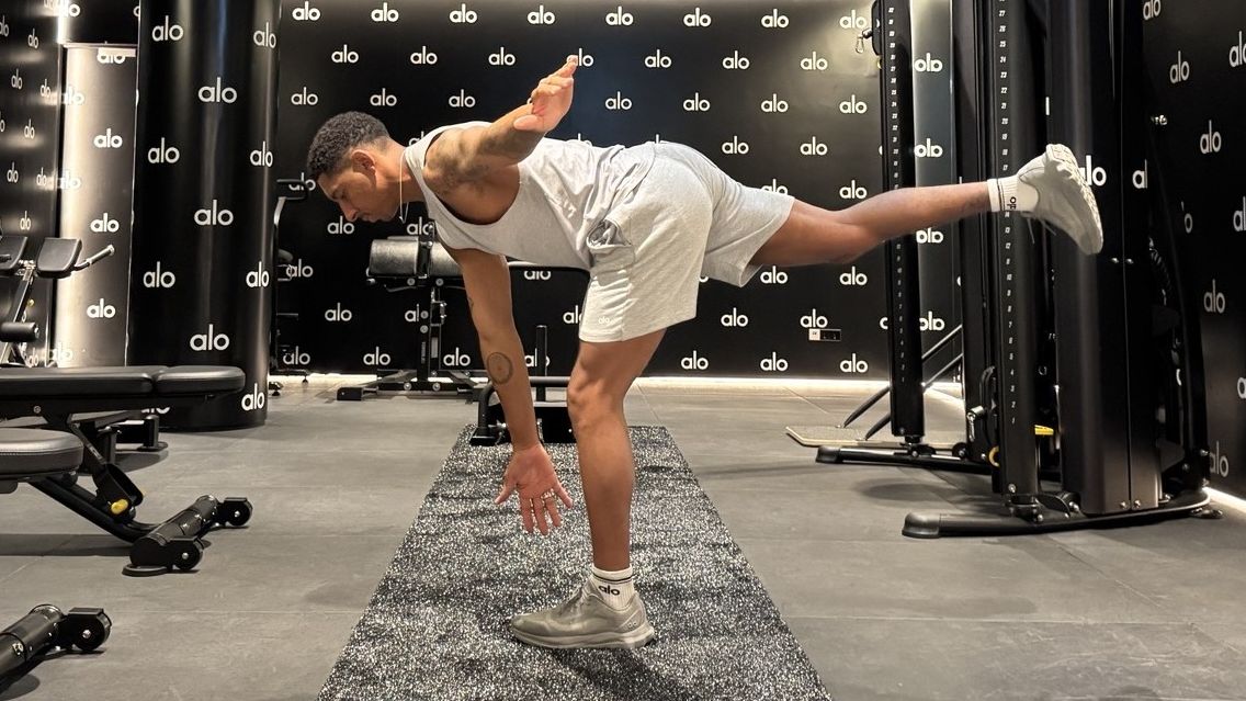 Man demonstrates single-leg Romanian deadlift exercise in gym