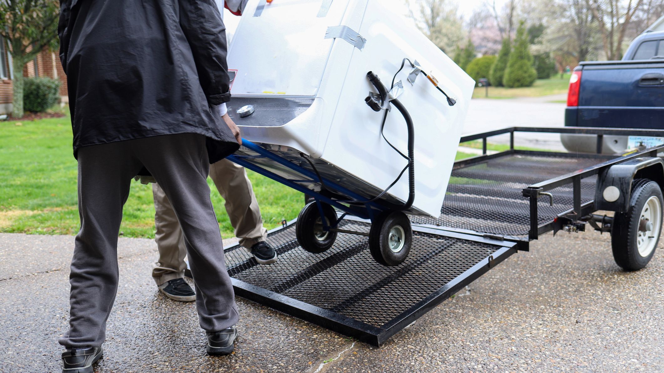 Two men loading a washer to be stored.