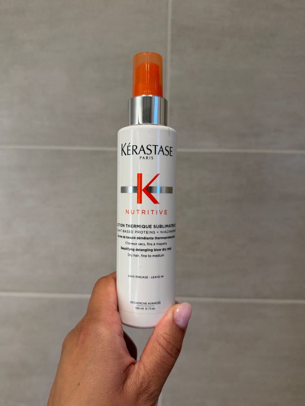 Aleesha holding empty Kerastase Nutritive hair spray