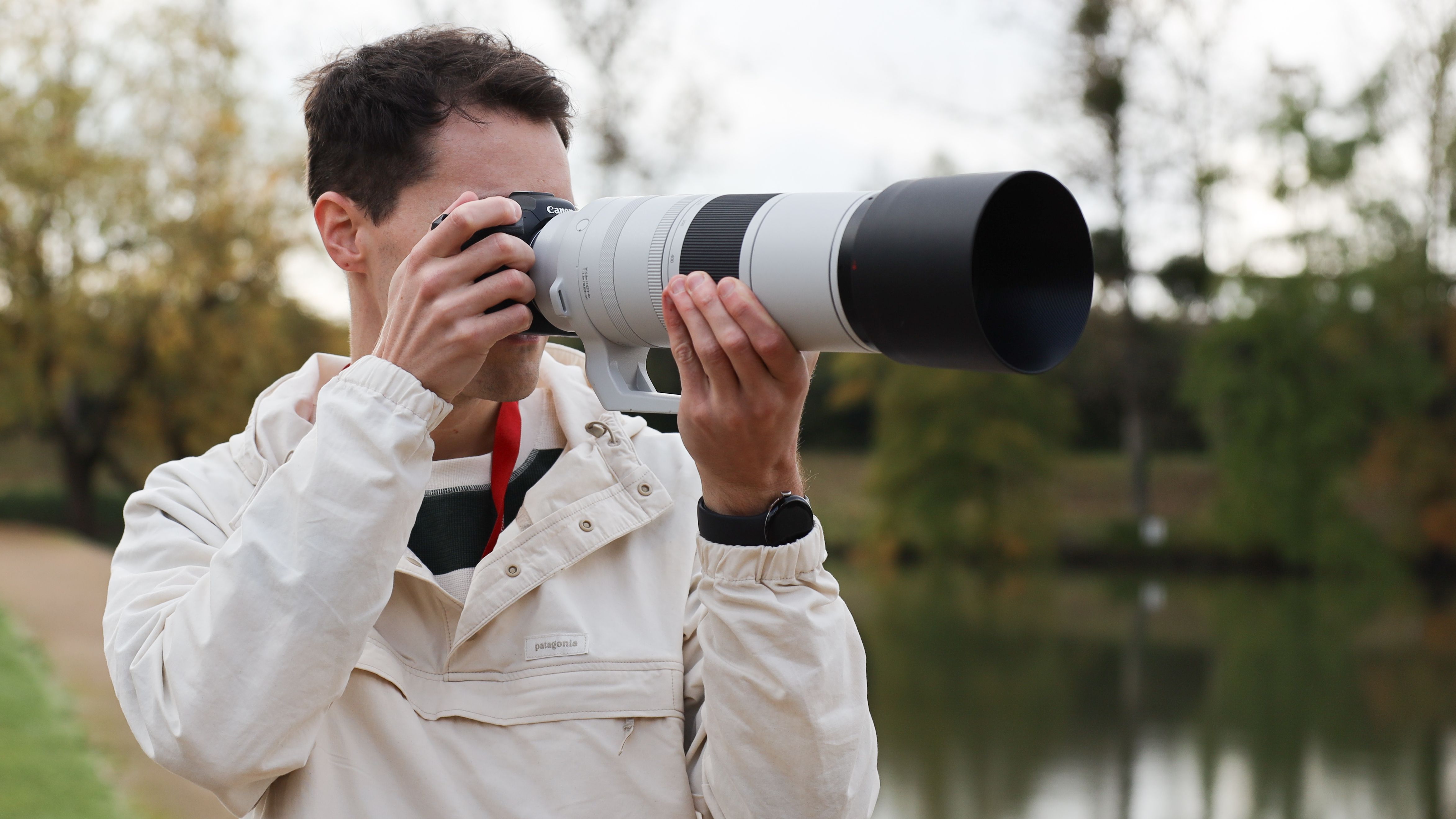 Canon RF 200-800mm f/6.3-9 IS USM lens on a Canon EOS R5 camera held up to man's face
