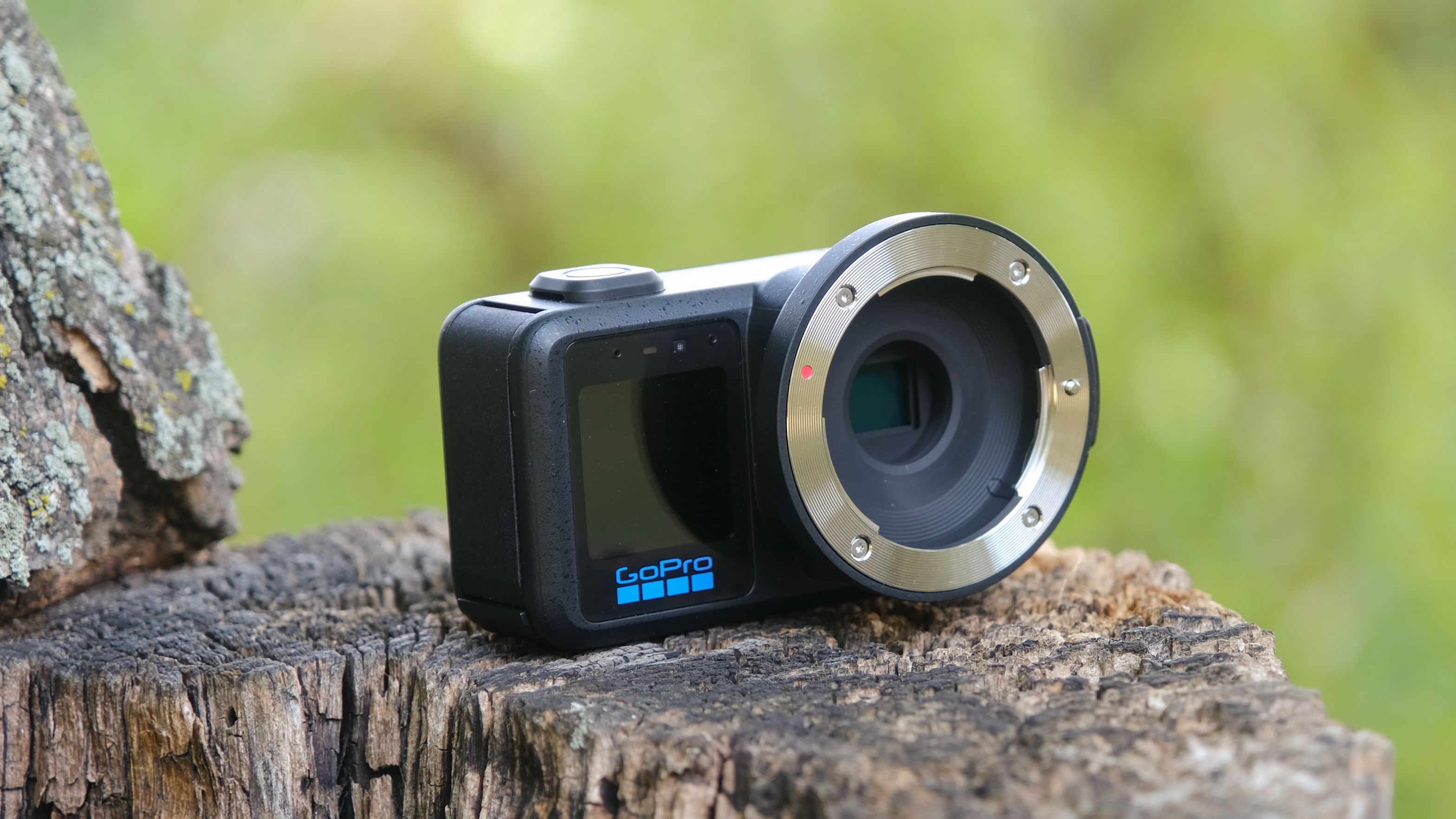 The GoPro Mission 1 ILS mirrorless camera photographed outdoors on a tree stump