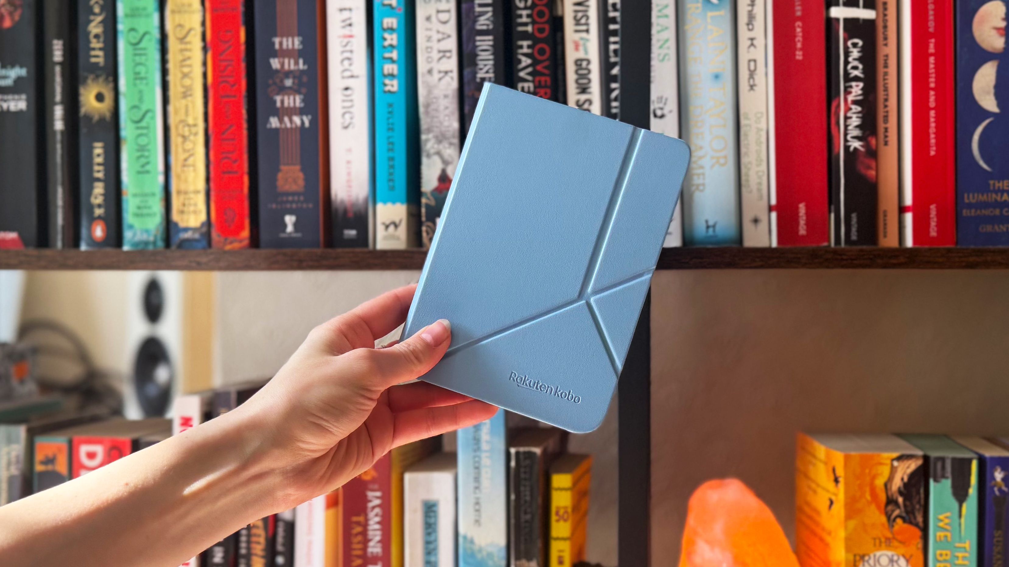 the kobo clara colour photographed in front of a bookshelf