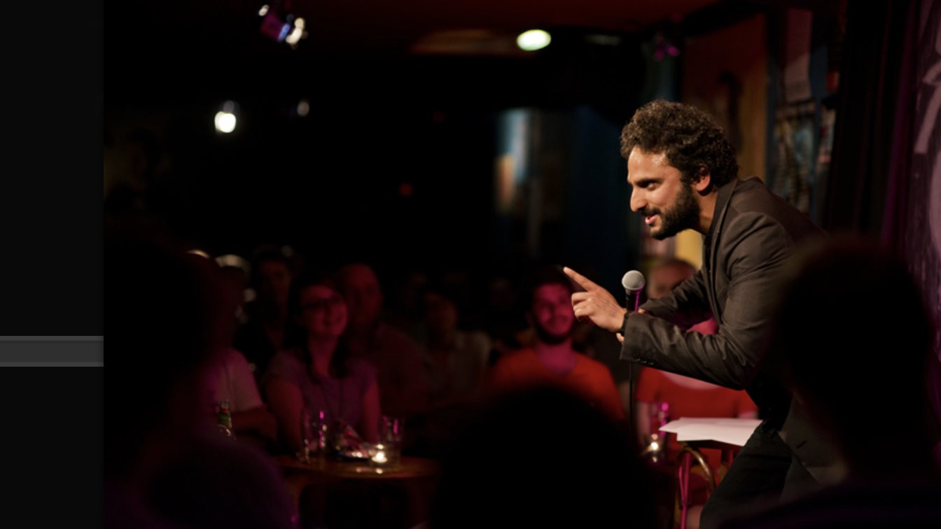 an image of Nish performing stand up on stage