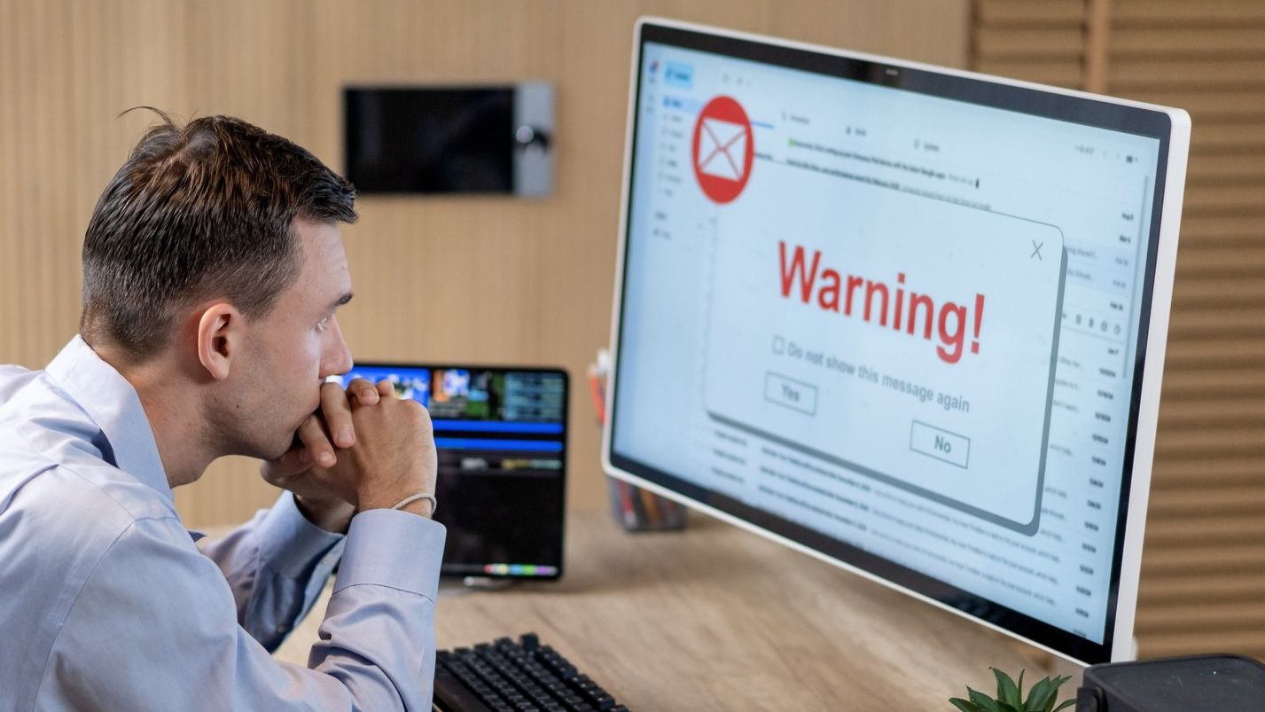 Businessman receiving phishing email warning on computer
