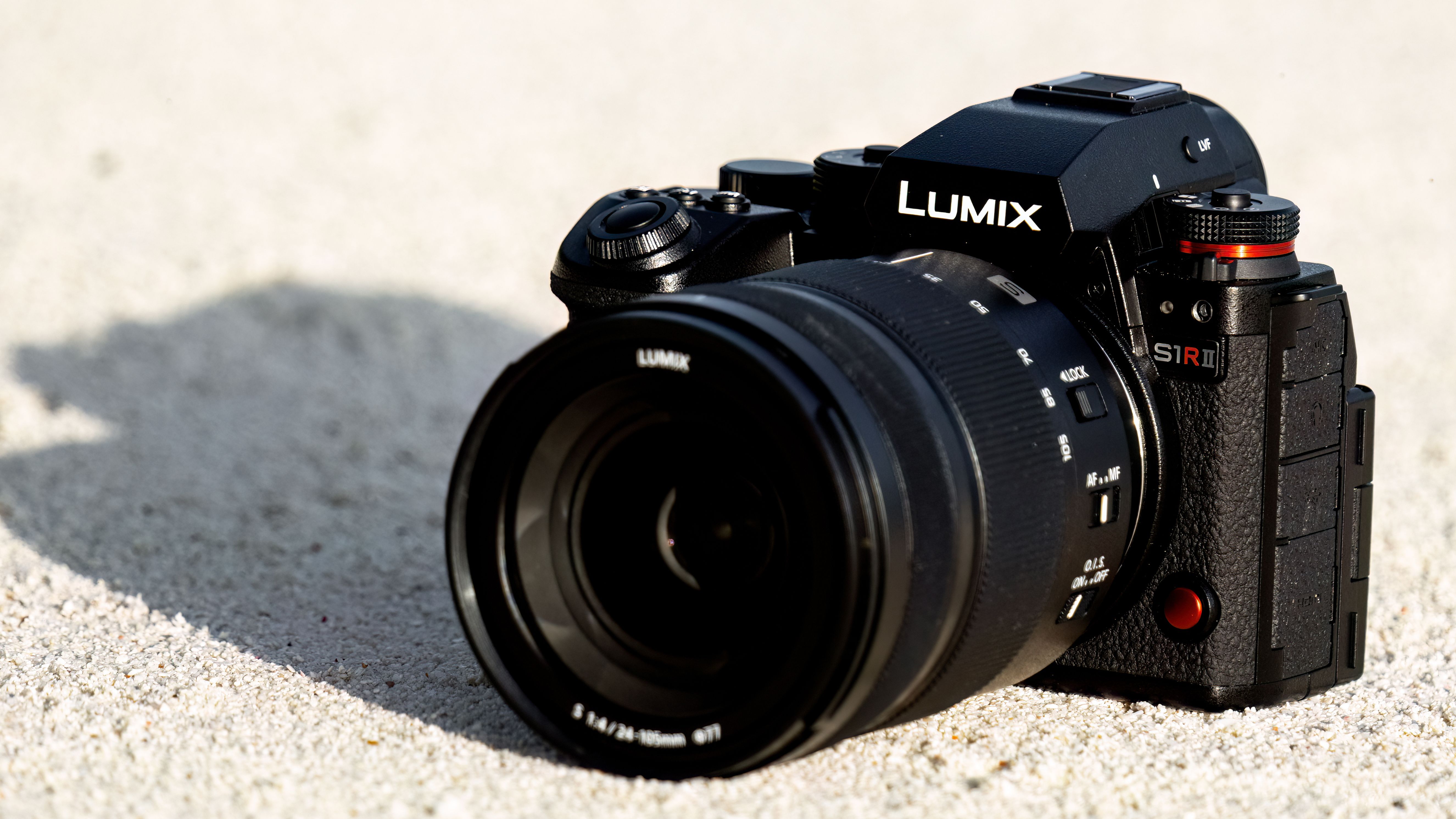 A lifestyle image of the Panasonic Lumix S1R II on a textured tan surface