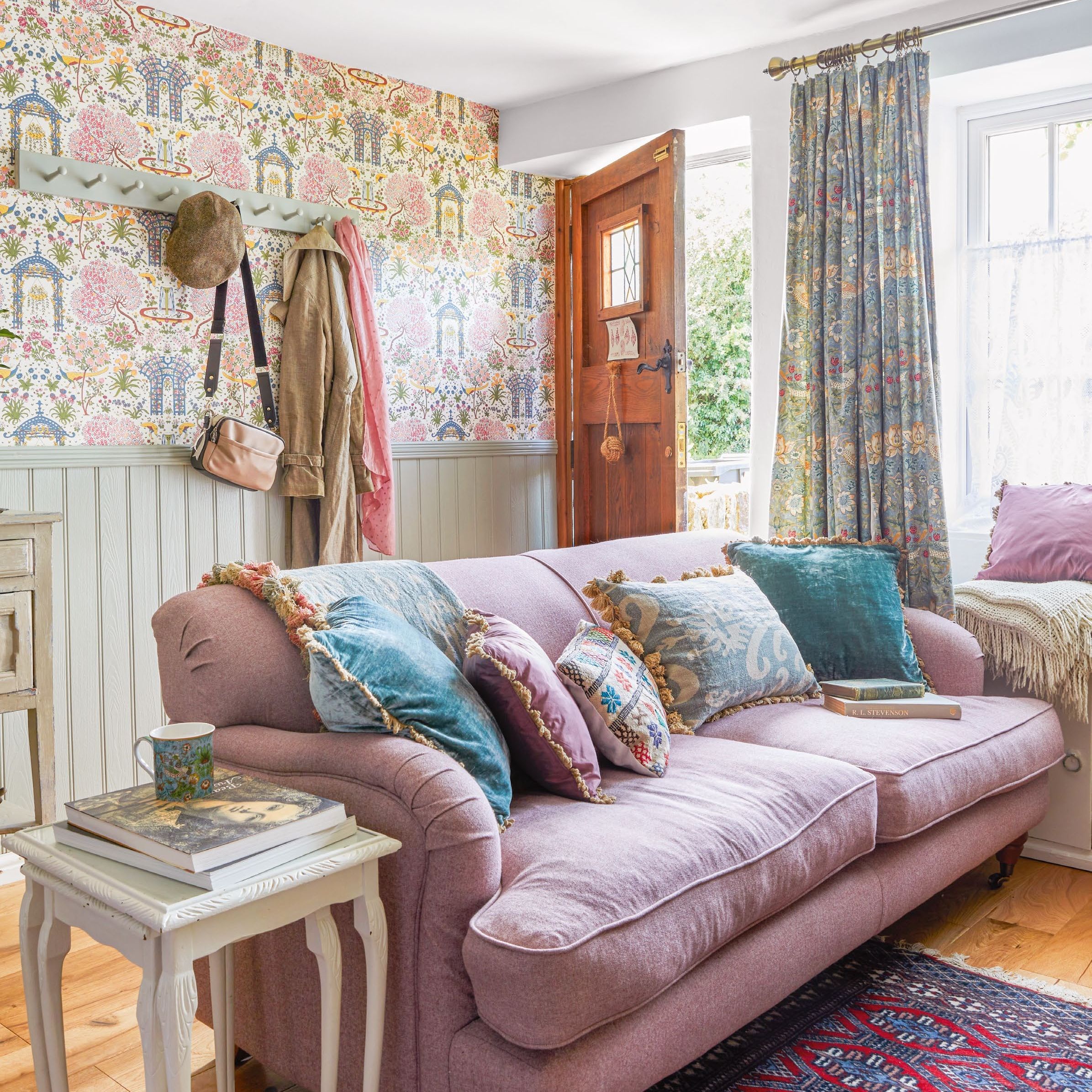 cottage living room with feature wallpaper, lilac sofa and door leading outdoors