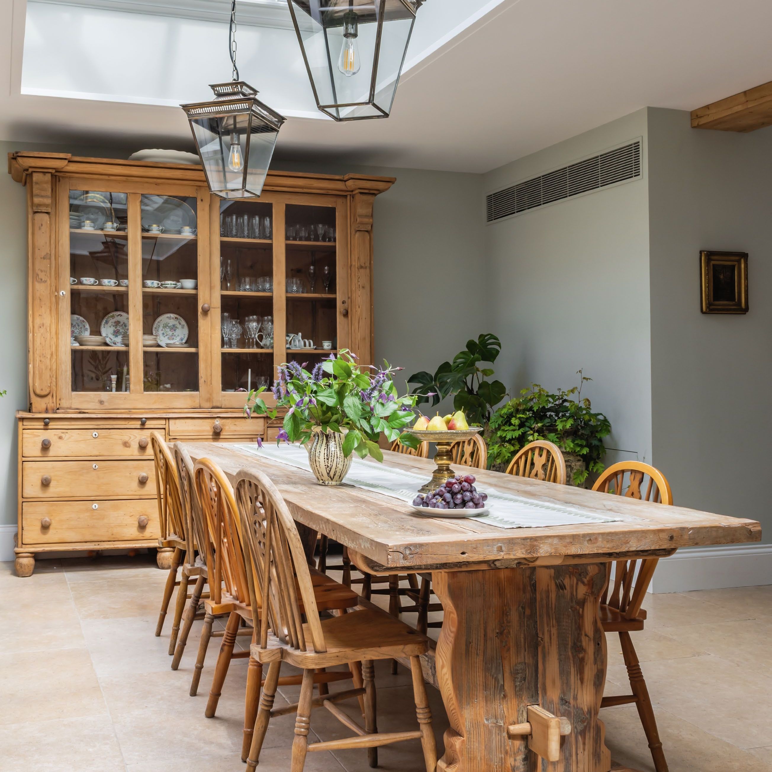 Antique dining table, chairs and dresser under a large roof lantern with pendant lantern lights