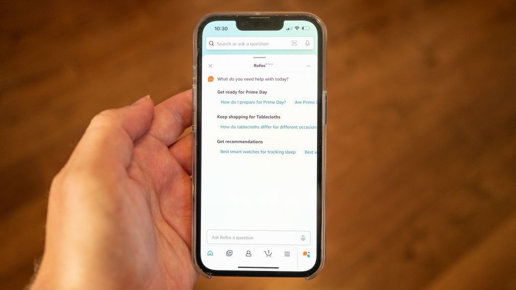 Person&#039;s hand holding an iPhone and using the Amazon Rufus AI system