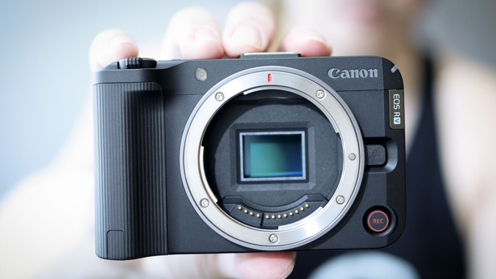 Canon EOS R50 V being held up, showing its image sensor
