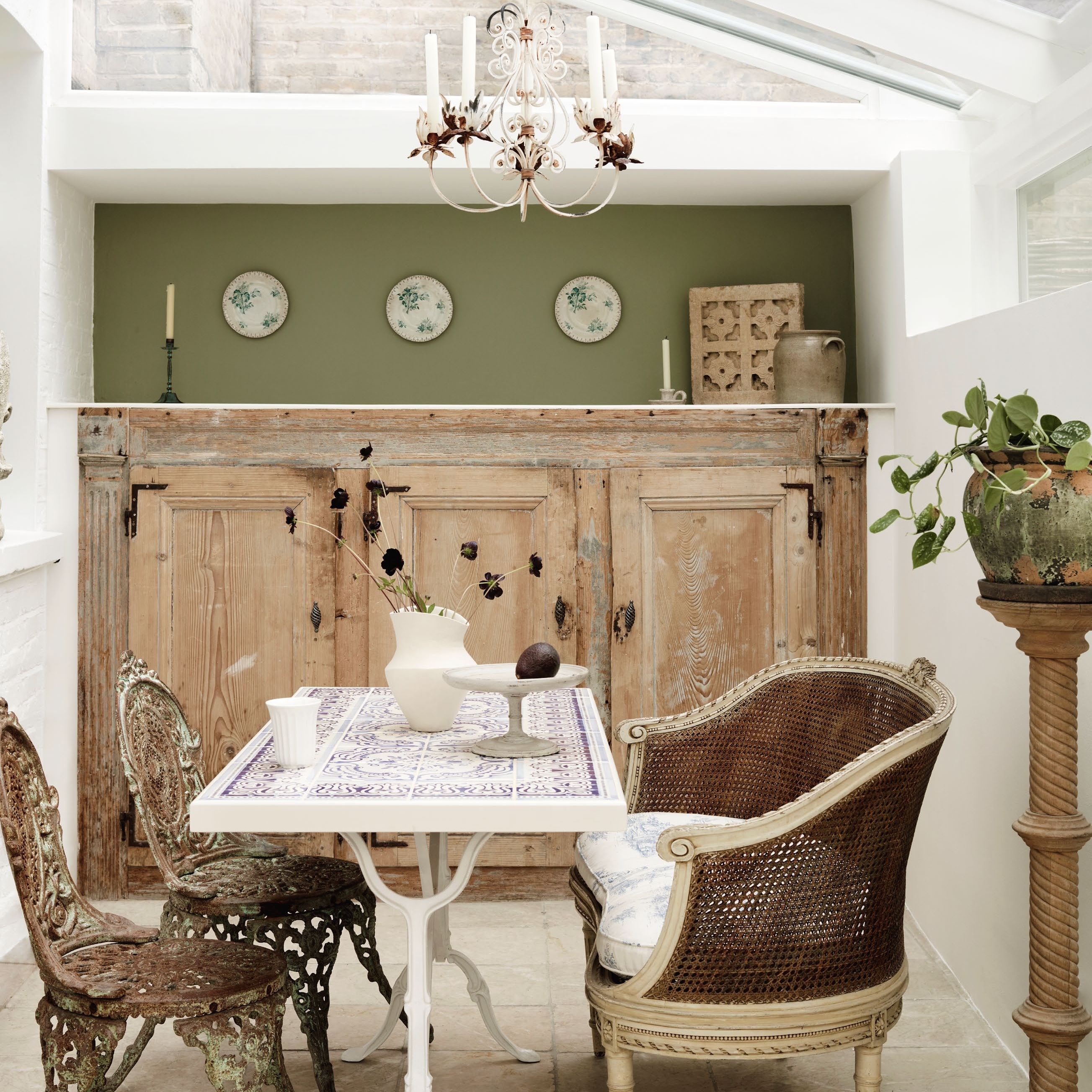 lean-to conservatory with large antique wooden cupboard and antique garden furniture