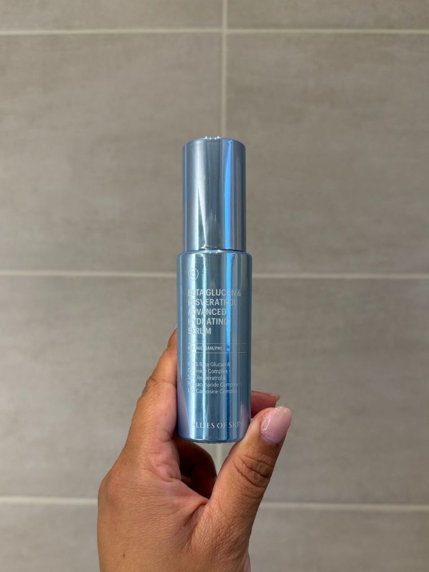 Aleesha holding empty allies of skin beta glucan &amp;amp; resveratrol advanced hydrating serum