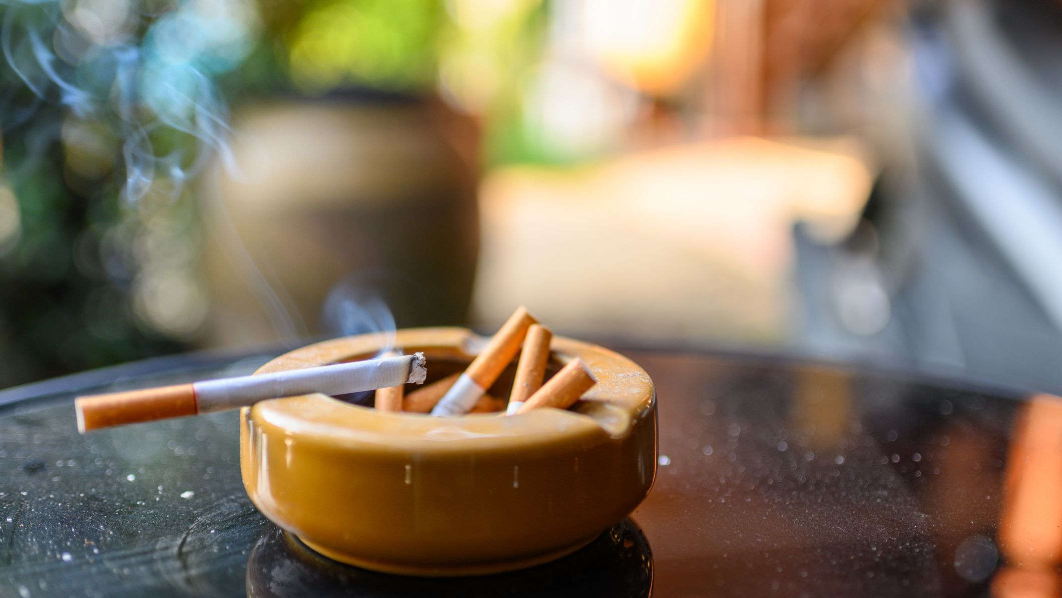 Cigarette burning with smoking on ceramic ashtray