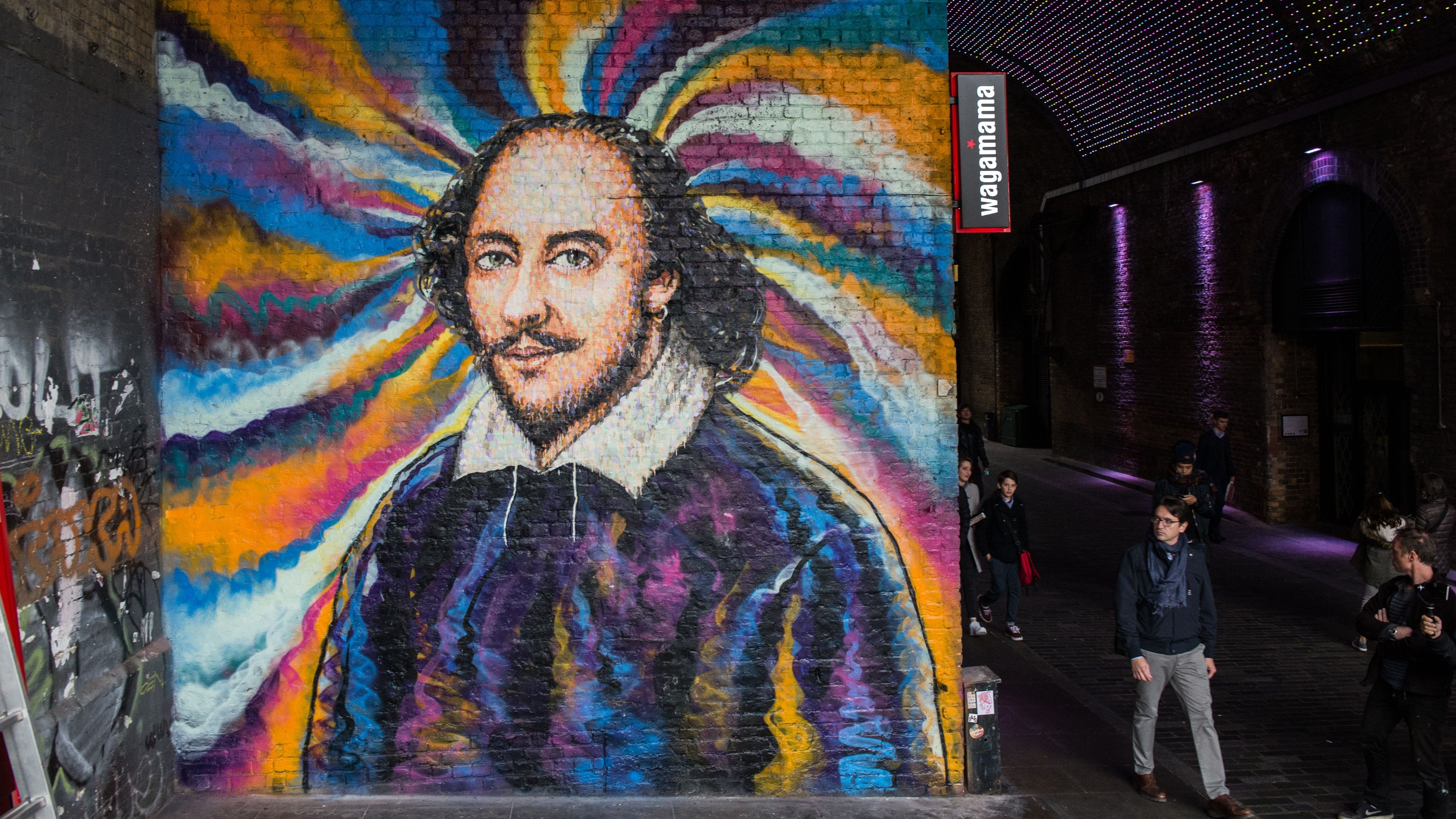 Members of the public walk past a mural of William Shakespeare by graffiti artist James Cochran, aka Jimmy C, on Clink Street, near the Shakespeare&amp;amp;apos;s Globe theatre in London on October 25, 2016. - Jimmy C is well known for his large street murals and his David Bowie piece in Brixton, London, became a focal point earlier this year for tributes after the singer&amp;amp;apos;s death. The mural of Shakespeare is being done as a personal project with the permission of Network Rail to use the wall. (Photo by CHRIS J RATCLIFFE / AFP) / RESTRICTED TO EDITORIAL USE - MANDATORY MENTION OF THE ARTIST UPON PUBLICATION - TO ILLUSTRATE THE EVENT AS SPECIFIED IN THE CAPTION (Photo by CHRIS J RATCLIFFE/AFP via Getty Images)