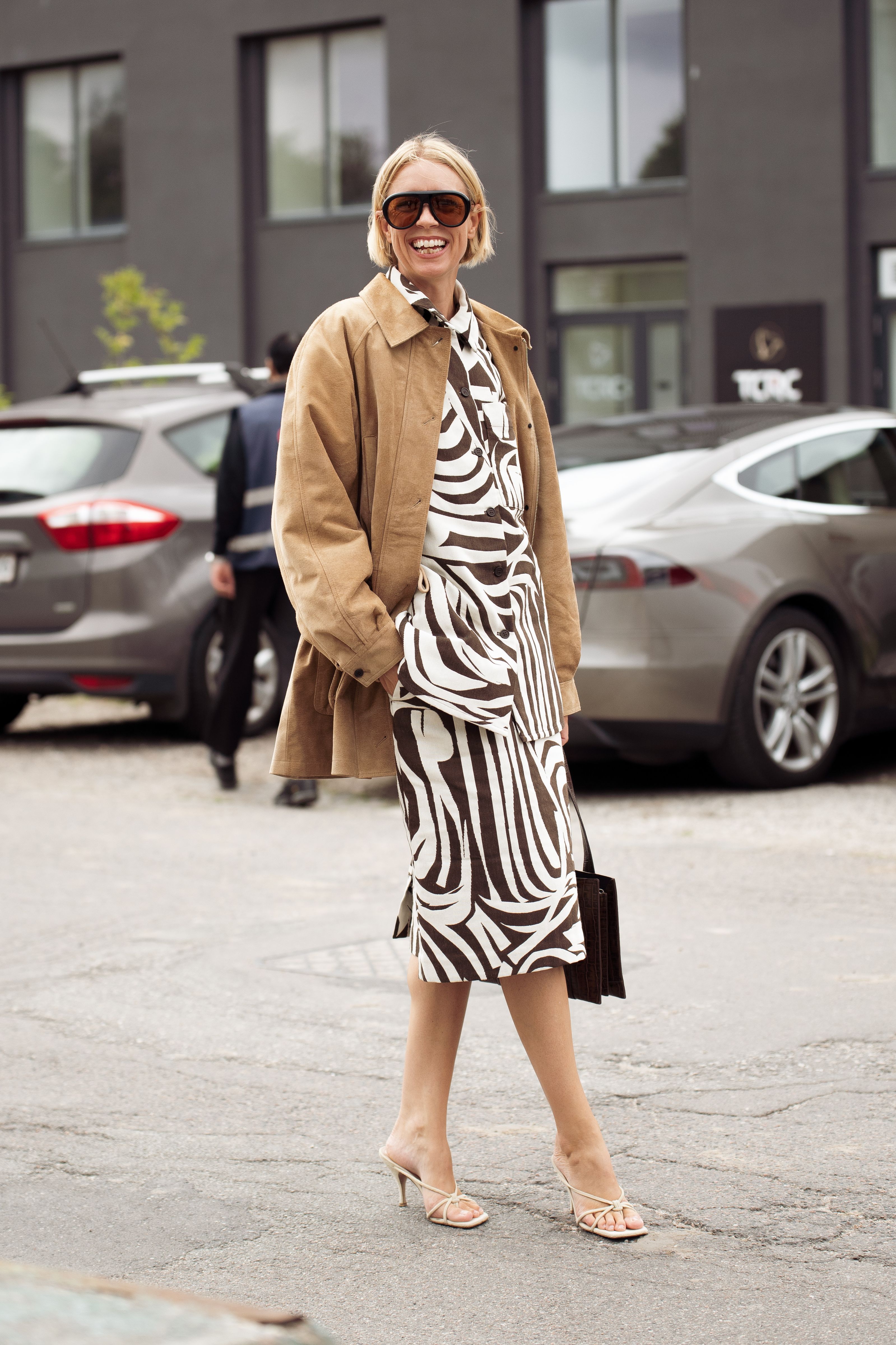 Hanna Stefansson wears white and black pattern dress, brown suede jacket and a black bag outside Marimekko show during Copenhagen Fashion Week day four on August 07, 2025 in Copenhagen, Denmark. (Photo by Raimonda Kulikauskiene/Getty Images)