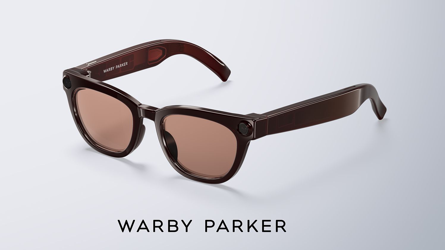 A pair of brown-tinted Warby Parker smart glasses with thick temples and corner camera lenses displayed over Google and Samsung logos.
