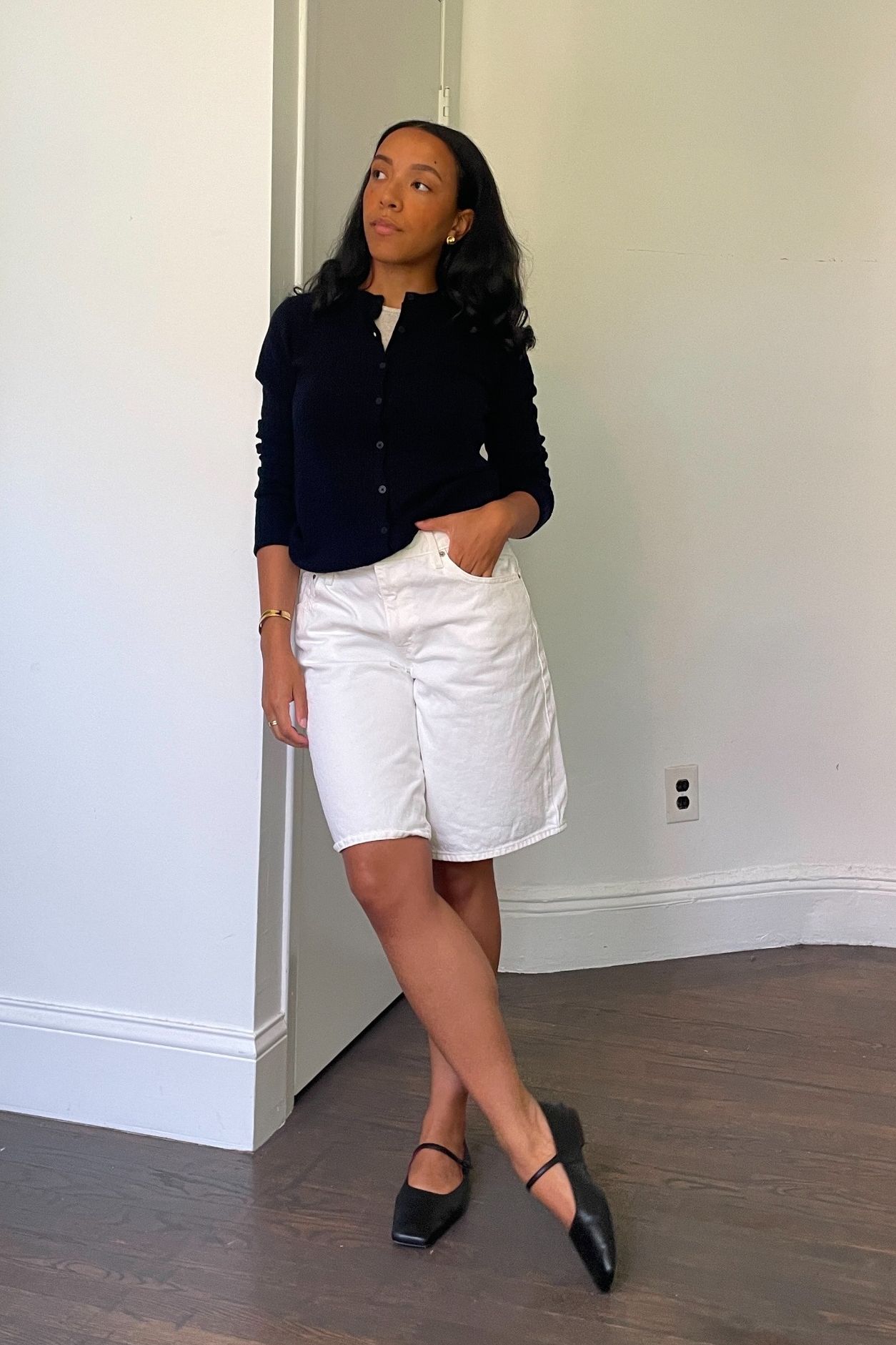Lauren Tappan wearing a sweater, white Bermuda shorts, and ballet flats