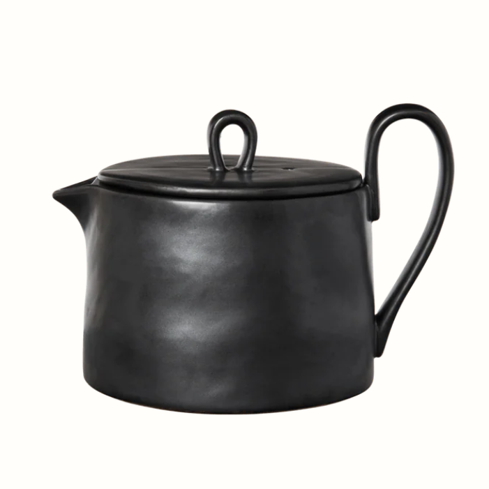 black teapot with oversized handle on white background