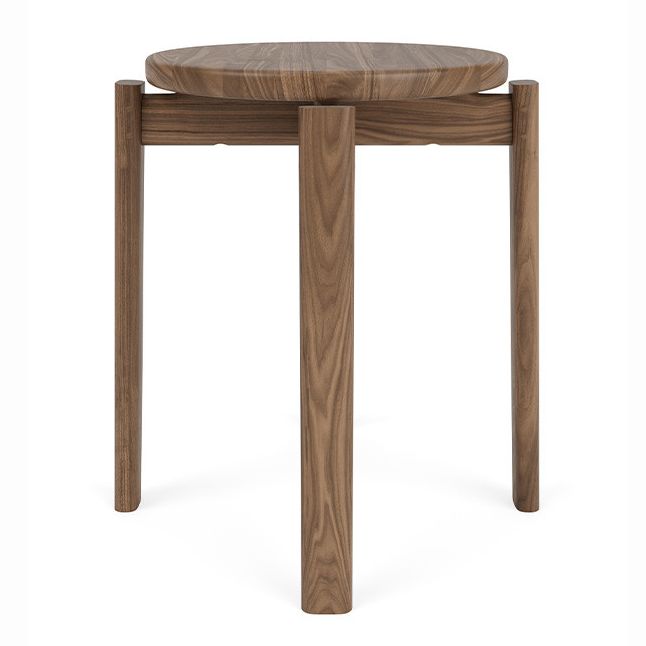 A brown wooden Audo Copenhagen Passage Stool with a round top and four legs
