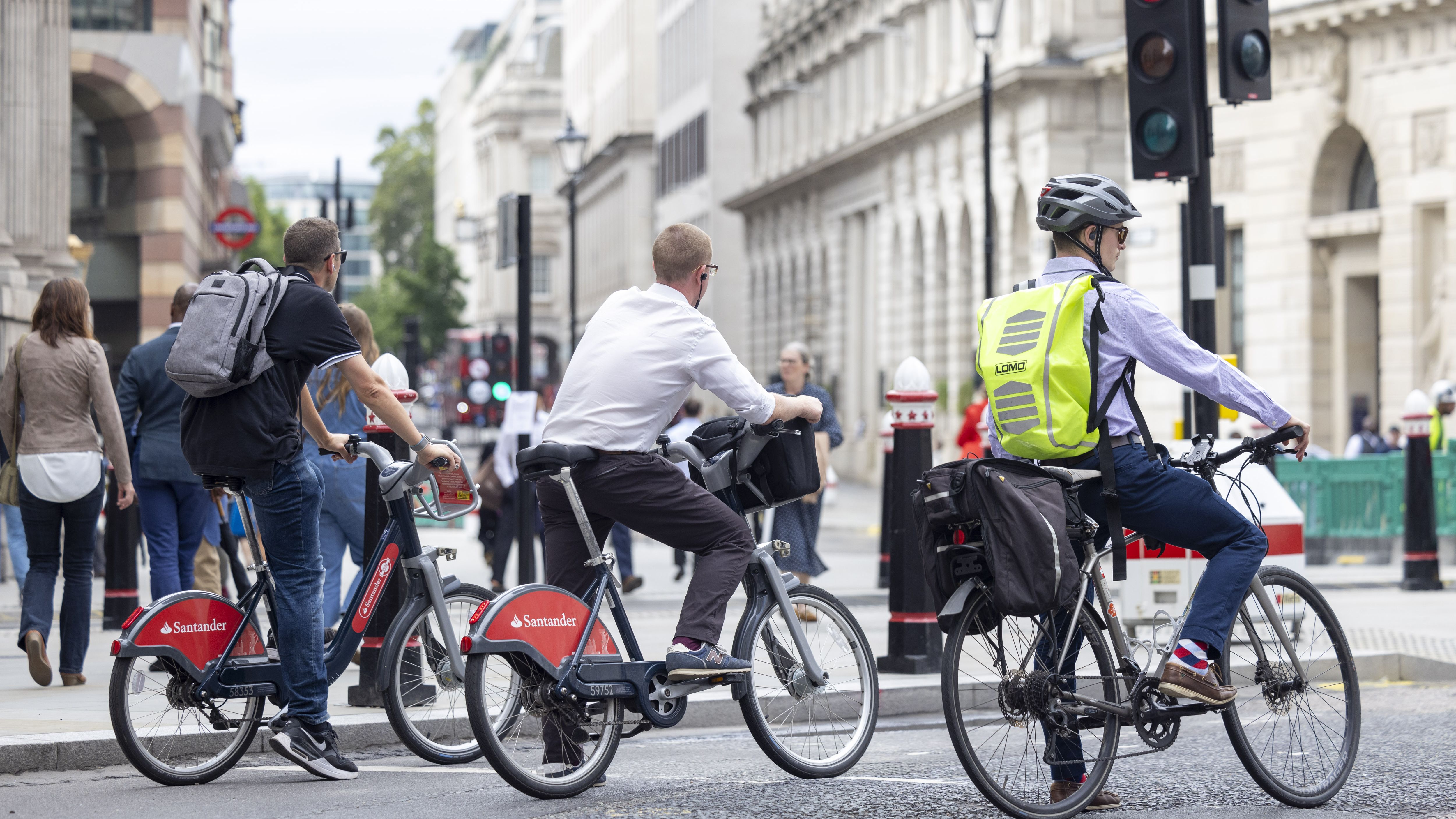Commuters on bikes wait at a junction in The City of London