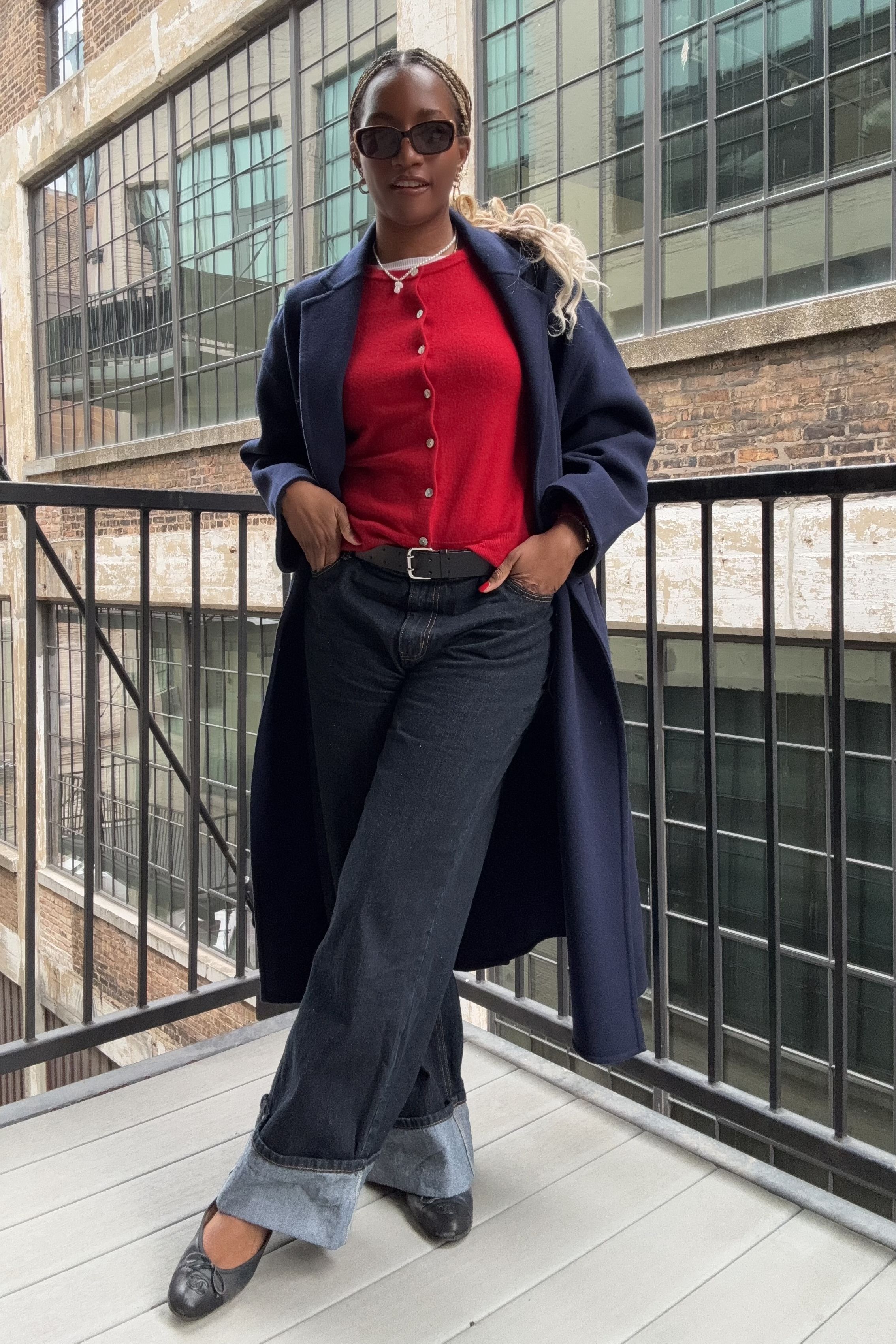 Danielle Prescod styles a navy outfit with a cherry red cardigan and ballet flats
