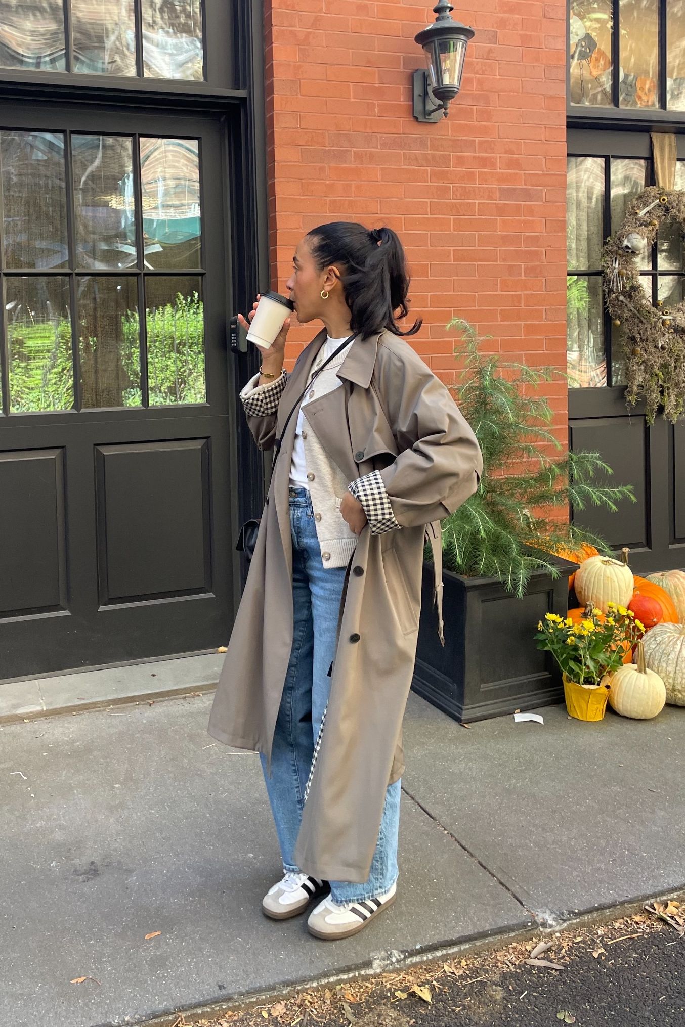 Lauren Tappan wearing a trench coat, jeans, and adidas sambas
