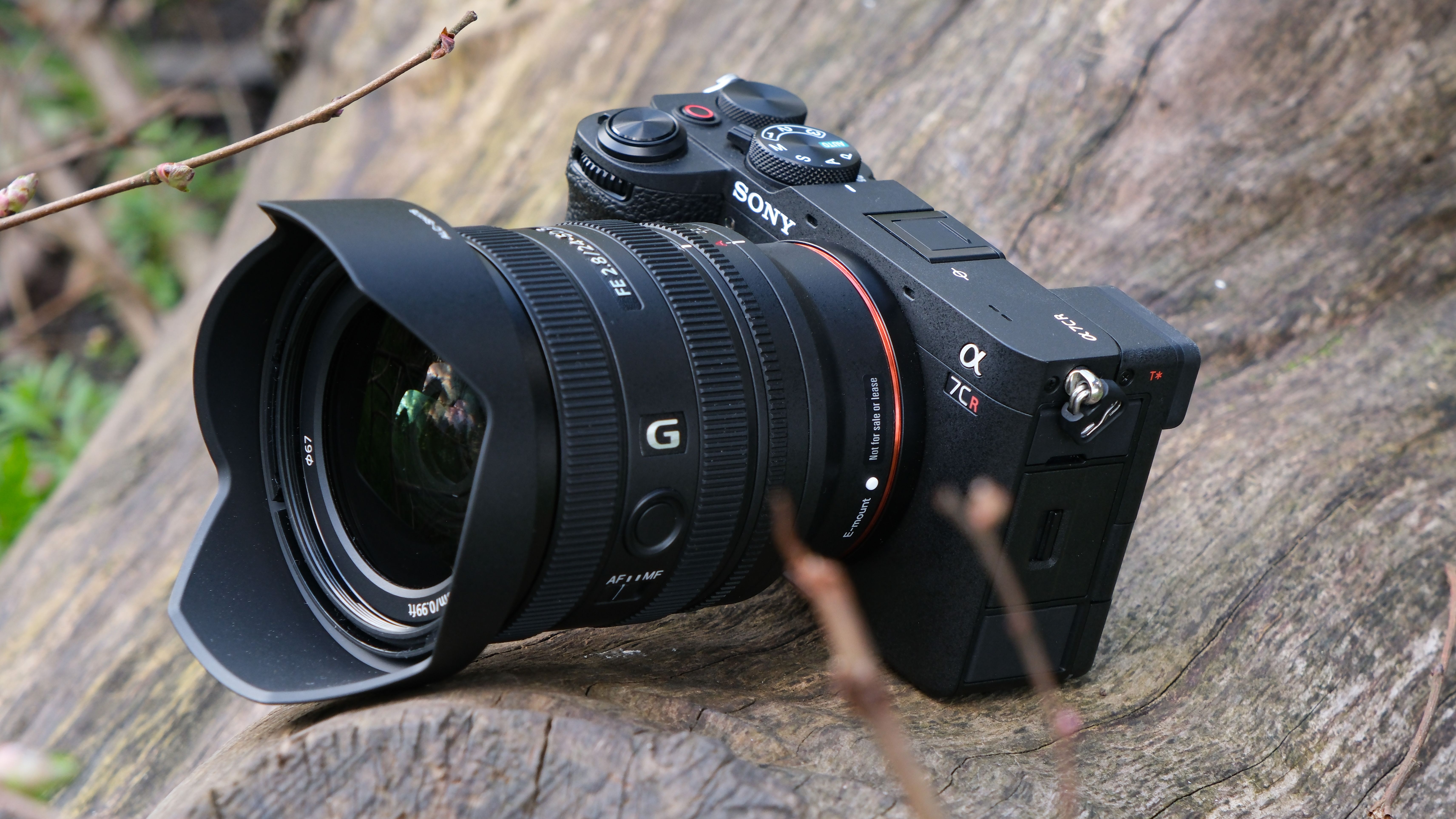Sony A7CR camera with a lens attached sat on a wooden log