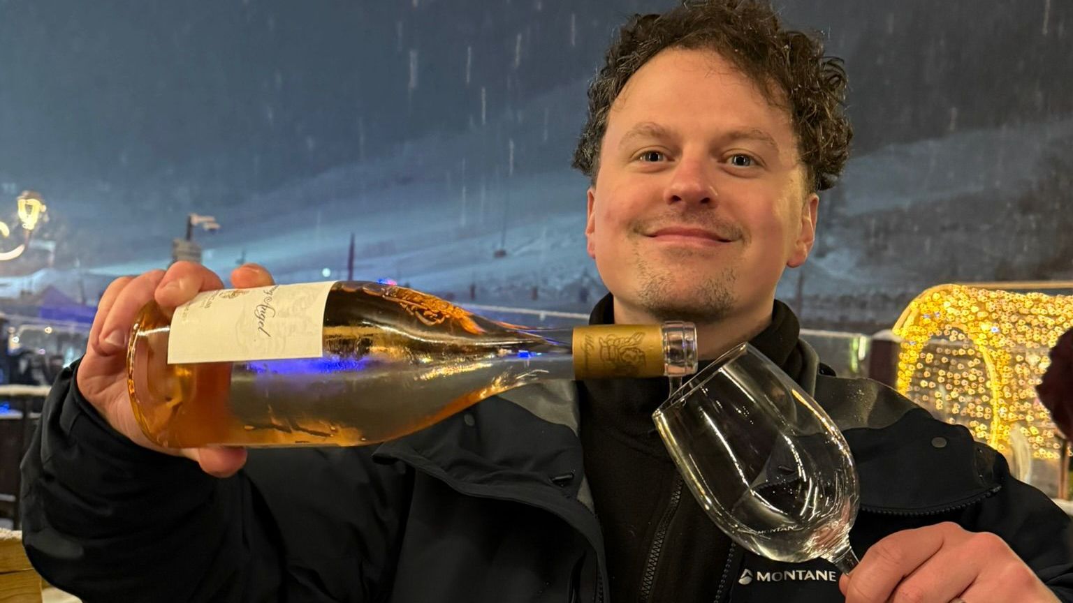 an image of a man pouring rose into a glass outside in the snow in courchevel