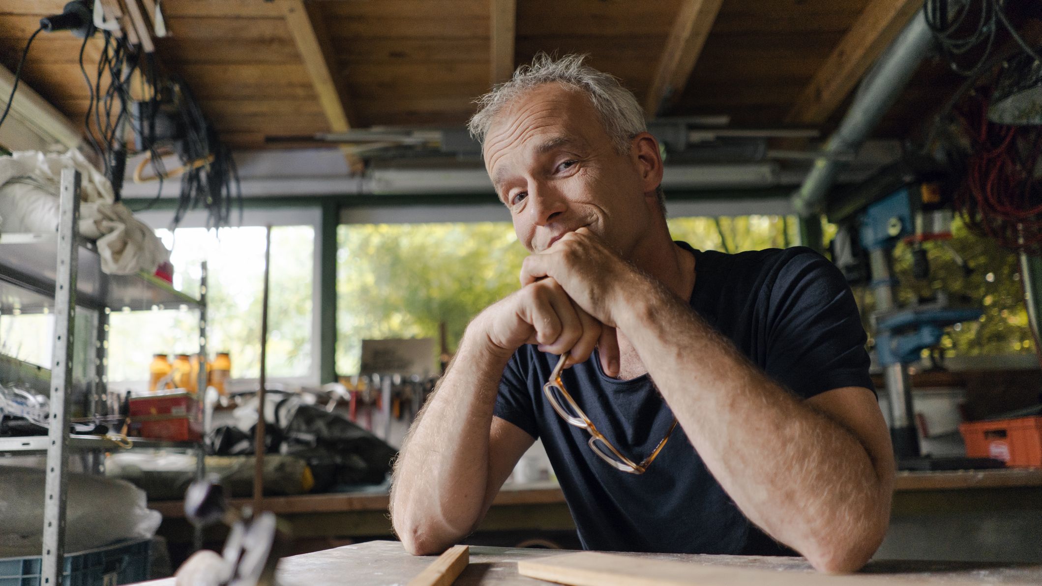 Portrait of confident mature man at workbench in his workshop.
