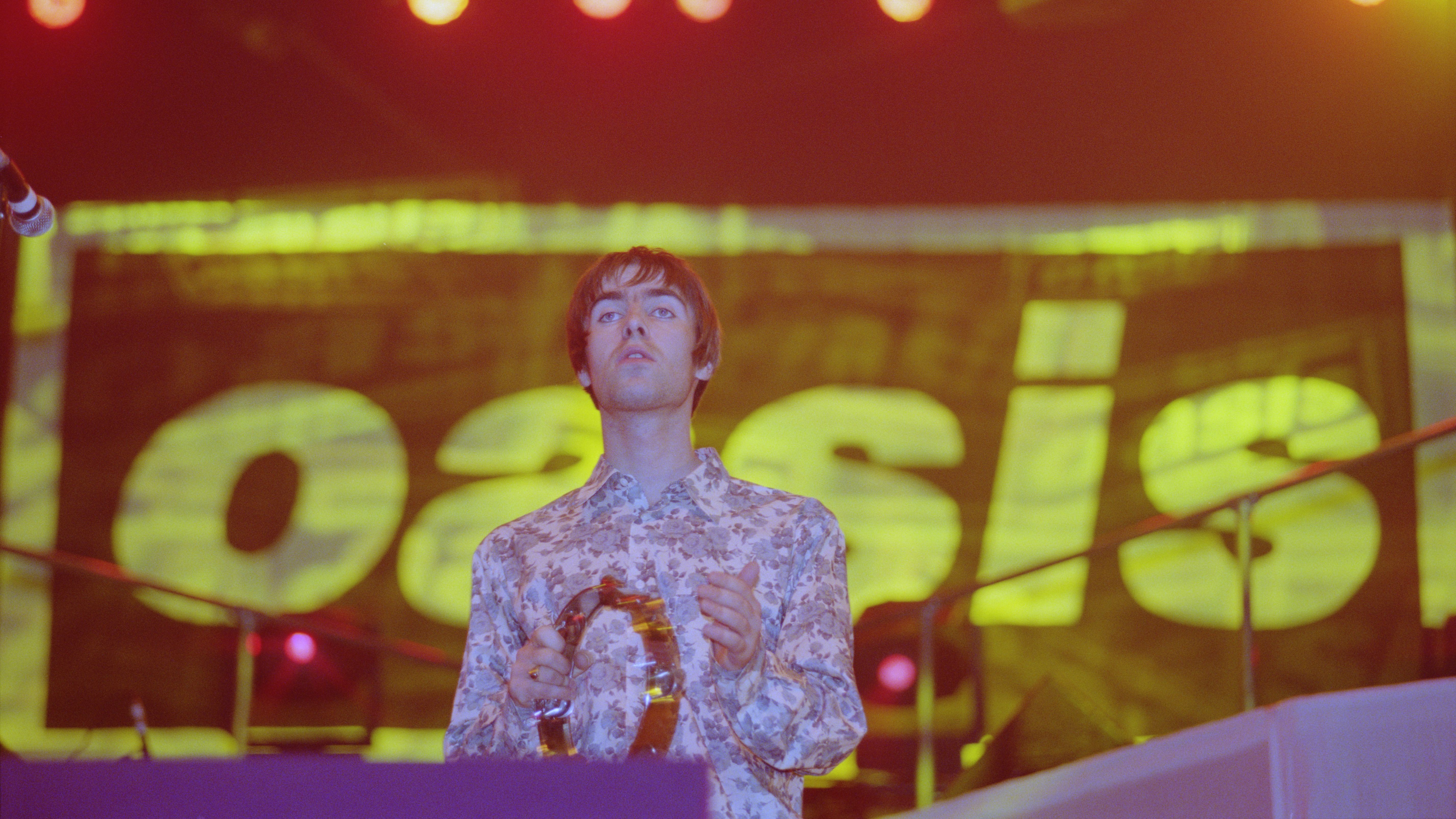 English musician Liam Gallagher, vocalist with Oasis, performs live on stage with the band at Earls Court Exhibition Centre in London in November 1995. (Photo by Brian Rasic/Getty Images)