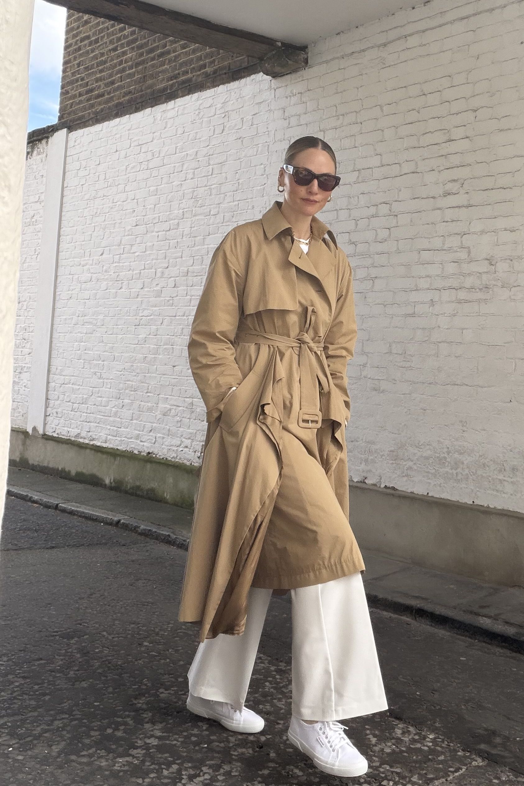 Brooke Ely Danielson wears her Superga sneakers with a classic trench coat and white pants