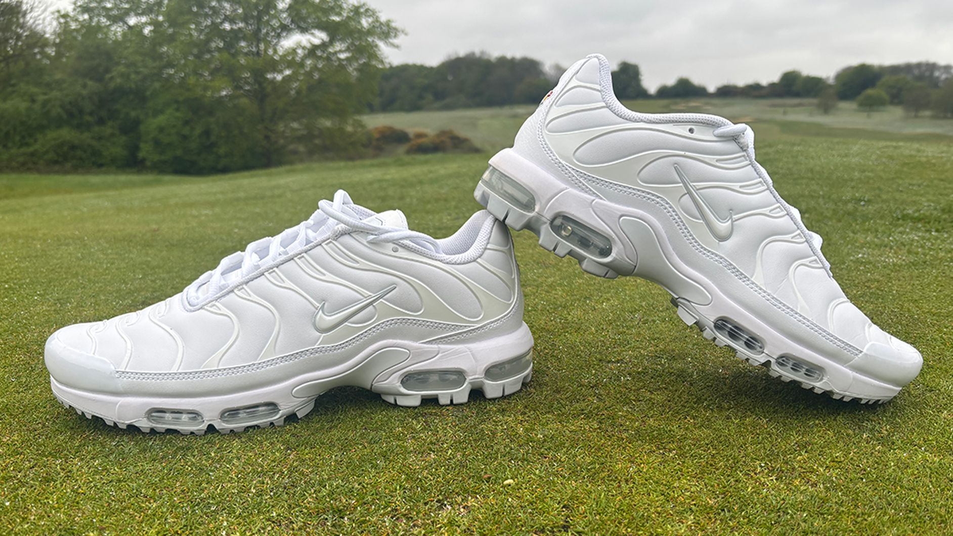 Nike Air Max Plus G Golf Shoes positioned with the left trainer on top of the right trainer on the putting green at Caversham Golf Club