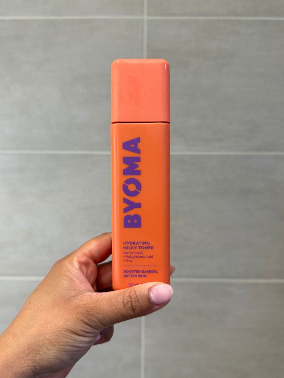 Aleesha holding empty Byoma Hydrating Milky Toner