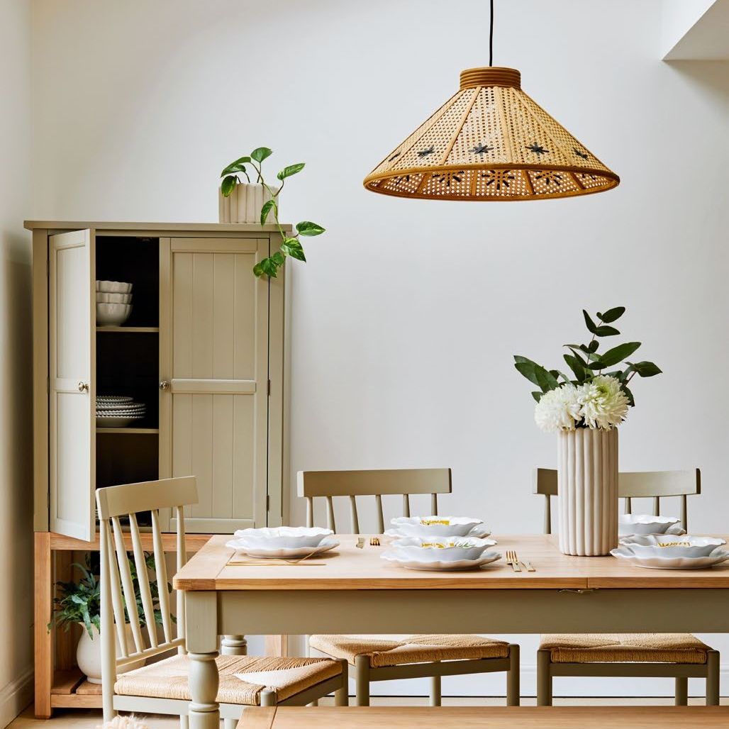 White room with wooden dining table, rug and rattan light shade