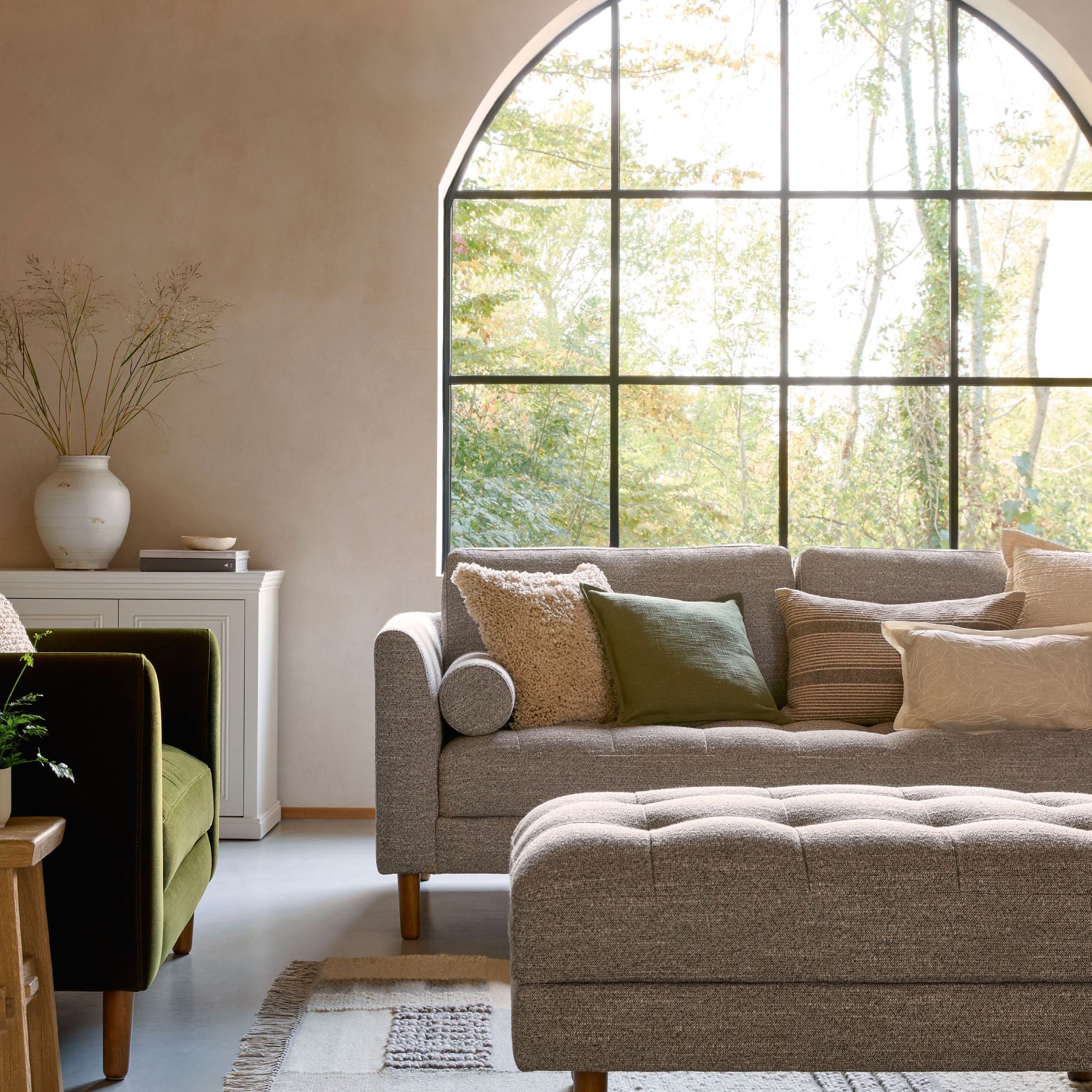 Natural room with arch window and a grey sofa