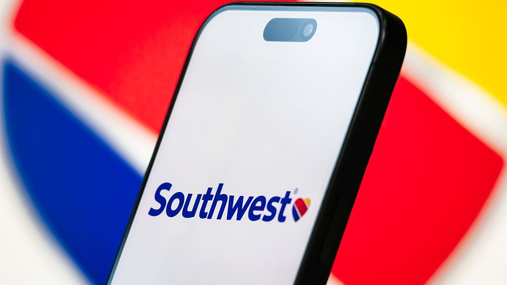 In this photo illustration, the Southwest Airlines logo is displayed on a smartphone screen, with the company's red, blue, and yellow heart branding visible in the background
