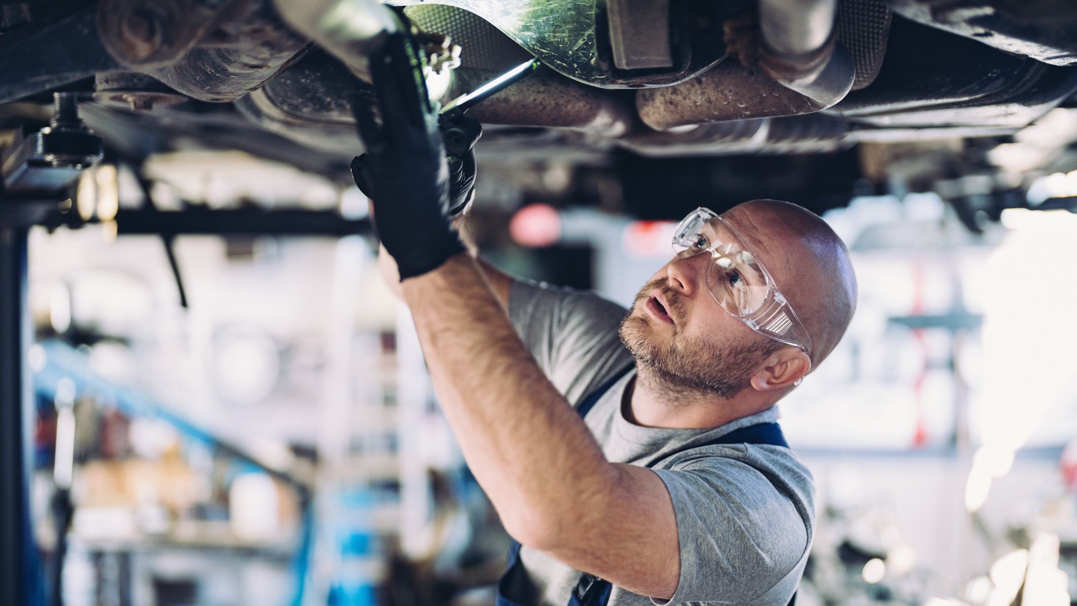 Mechanic examining undercarriage of a car