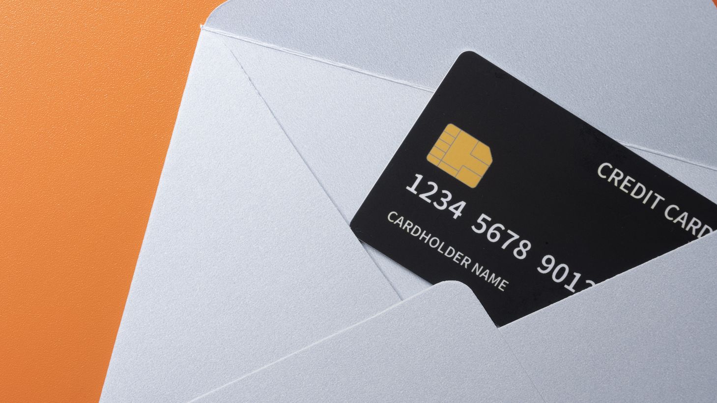 Top view of empty blank white envelope and postcard with credit card on colored background
