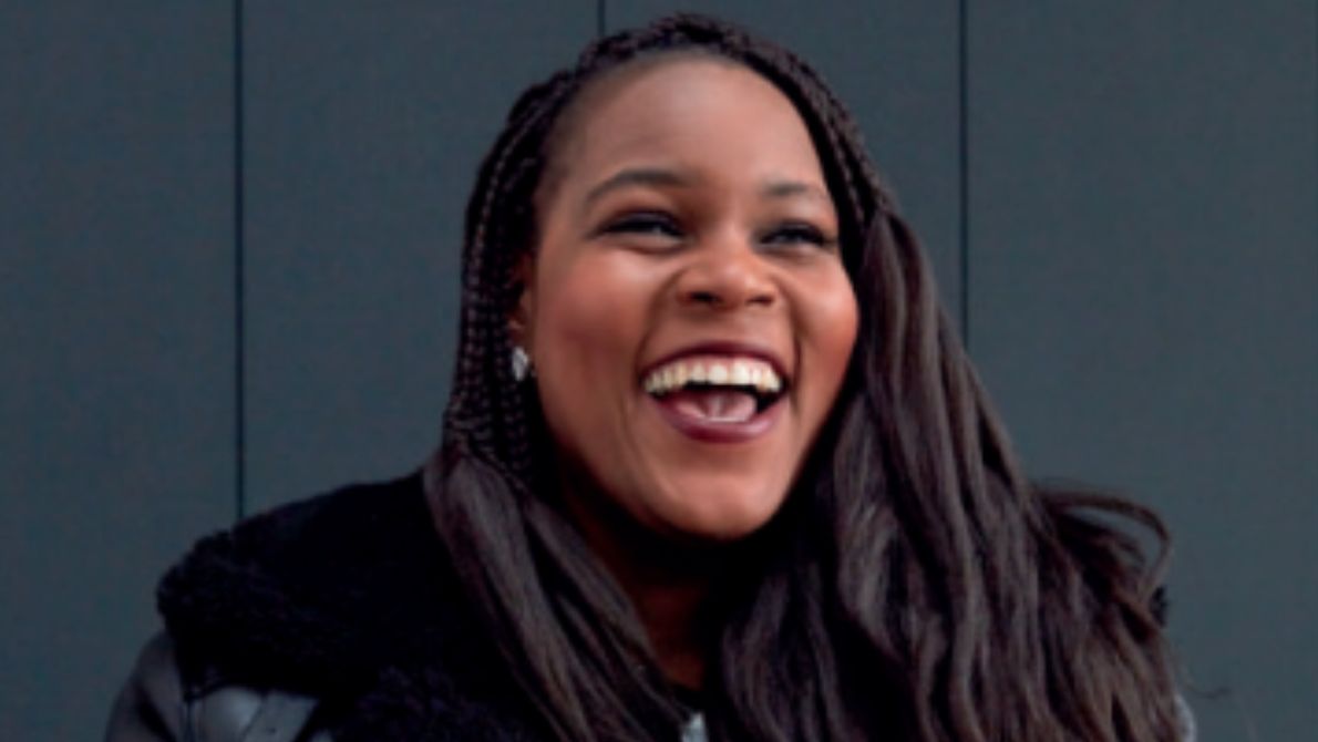 Image of Samantha Jameson smiling with brunette braids and wearing a black aviator jacket
