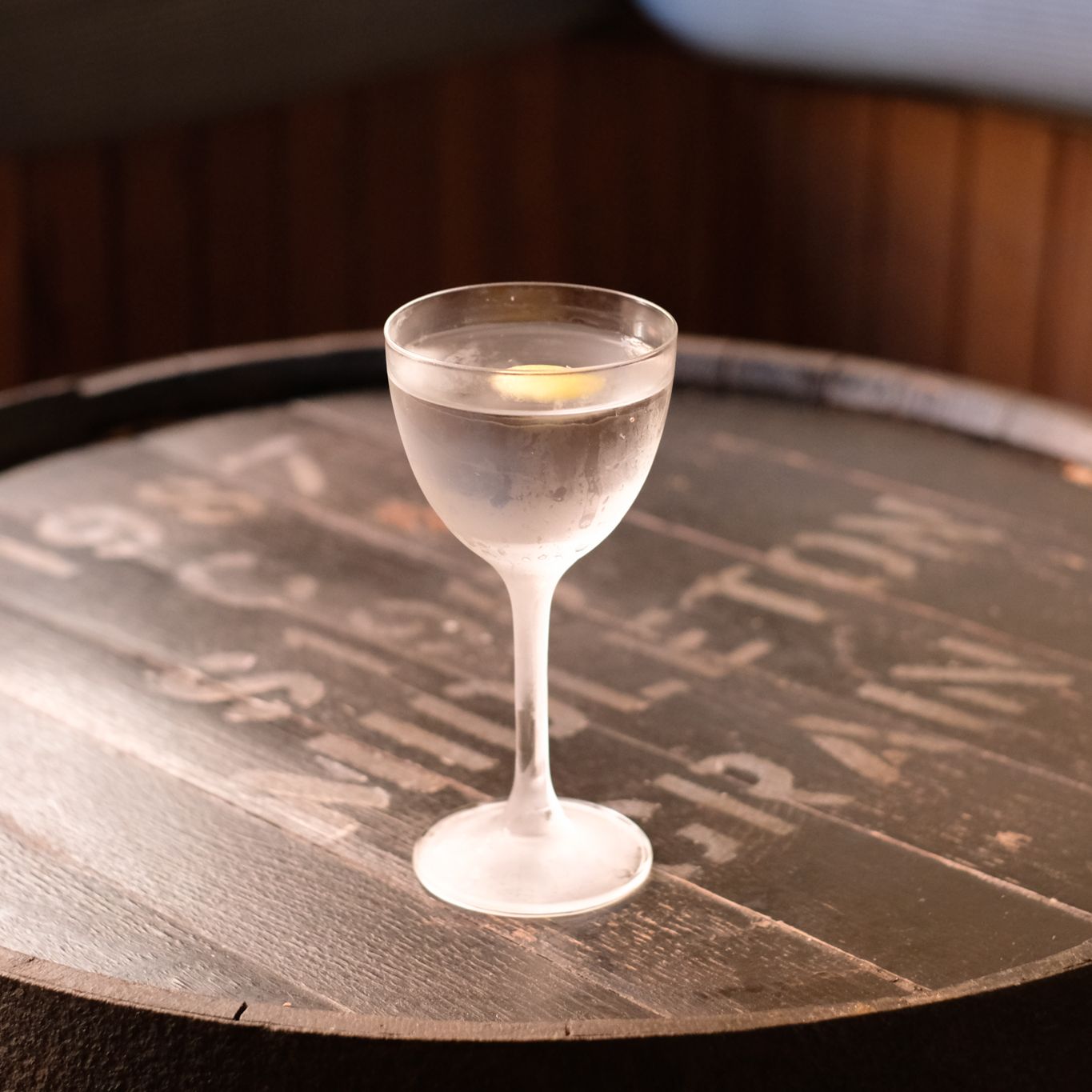 an image of a martini on a barrel style table in a cold glass