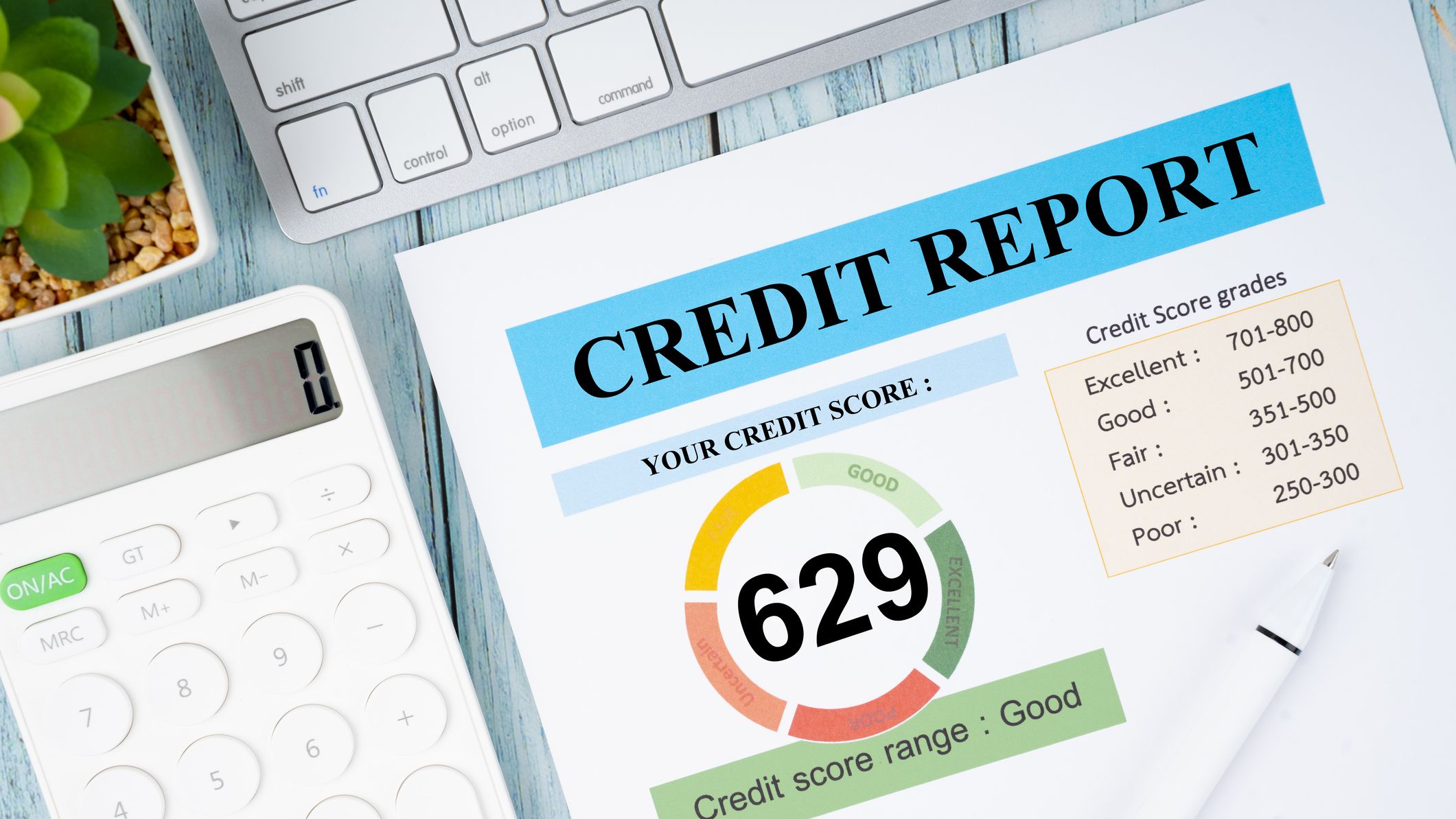 Credit report and calculator with computer keyboard on the desk.