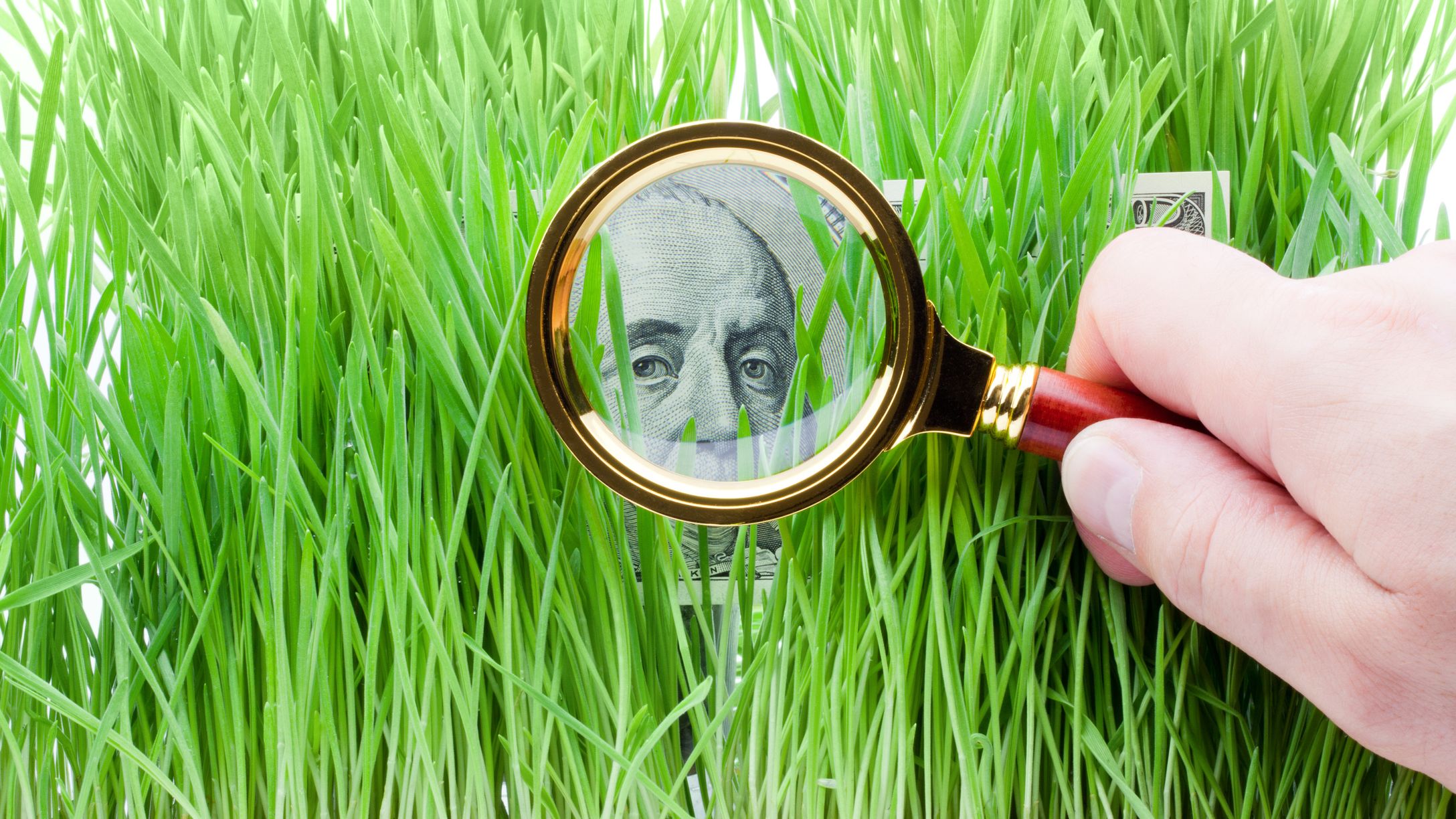 Detail of a one hundred dollar bill through a magnifying glass.