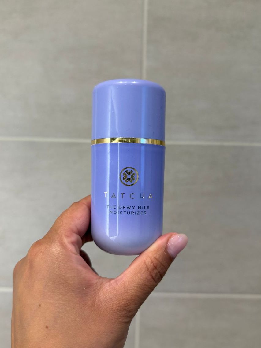 Aleesha holding empty Tatcha Dewy Milk Moisturiser