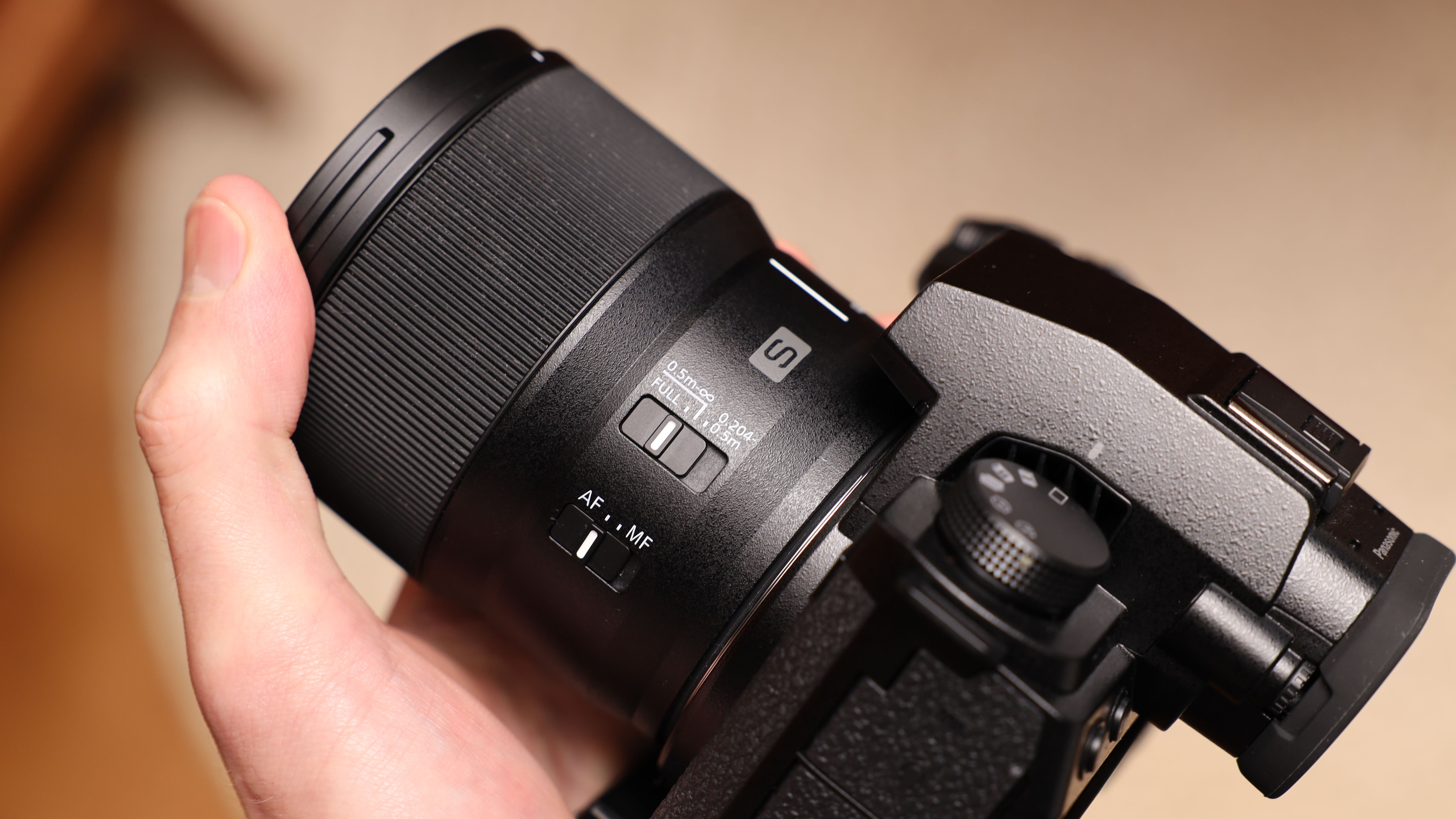 Panasonic Lumix S 100mm f/2.8 Macro held in a hand