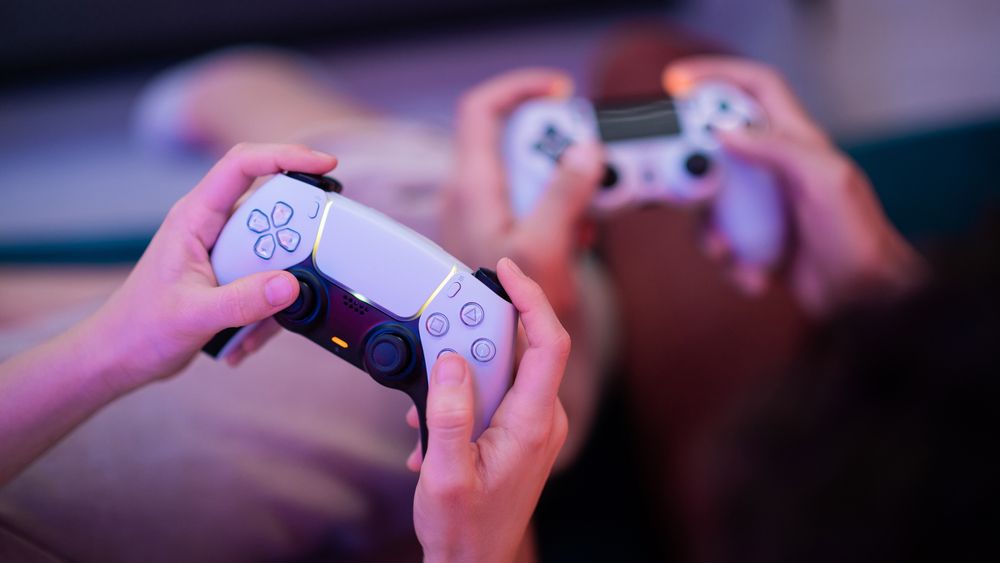 Children playing video games with a PS5 controller