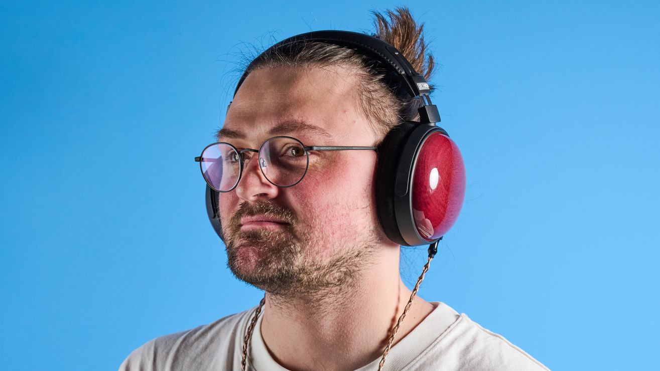 the fiio ft13 wired headphones with wood cups and copper cable photographed against a blue background