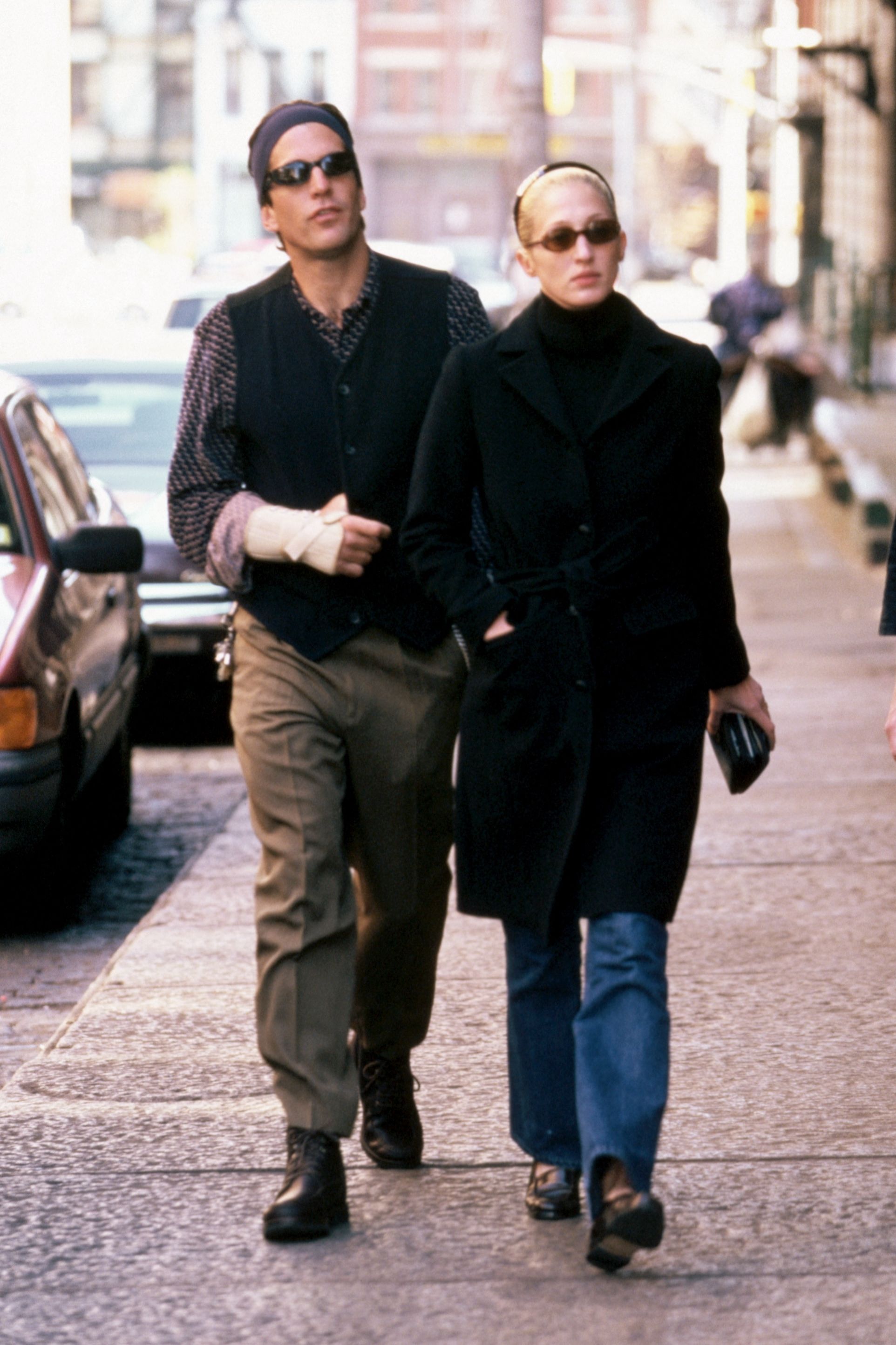 John F. Kennedy Jr. walks along a New York City street with wife Carolyn Bessette.