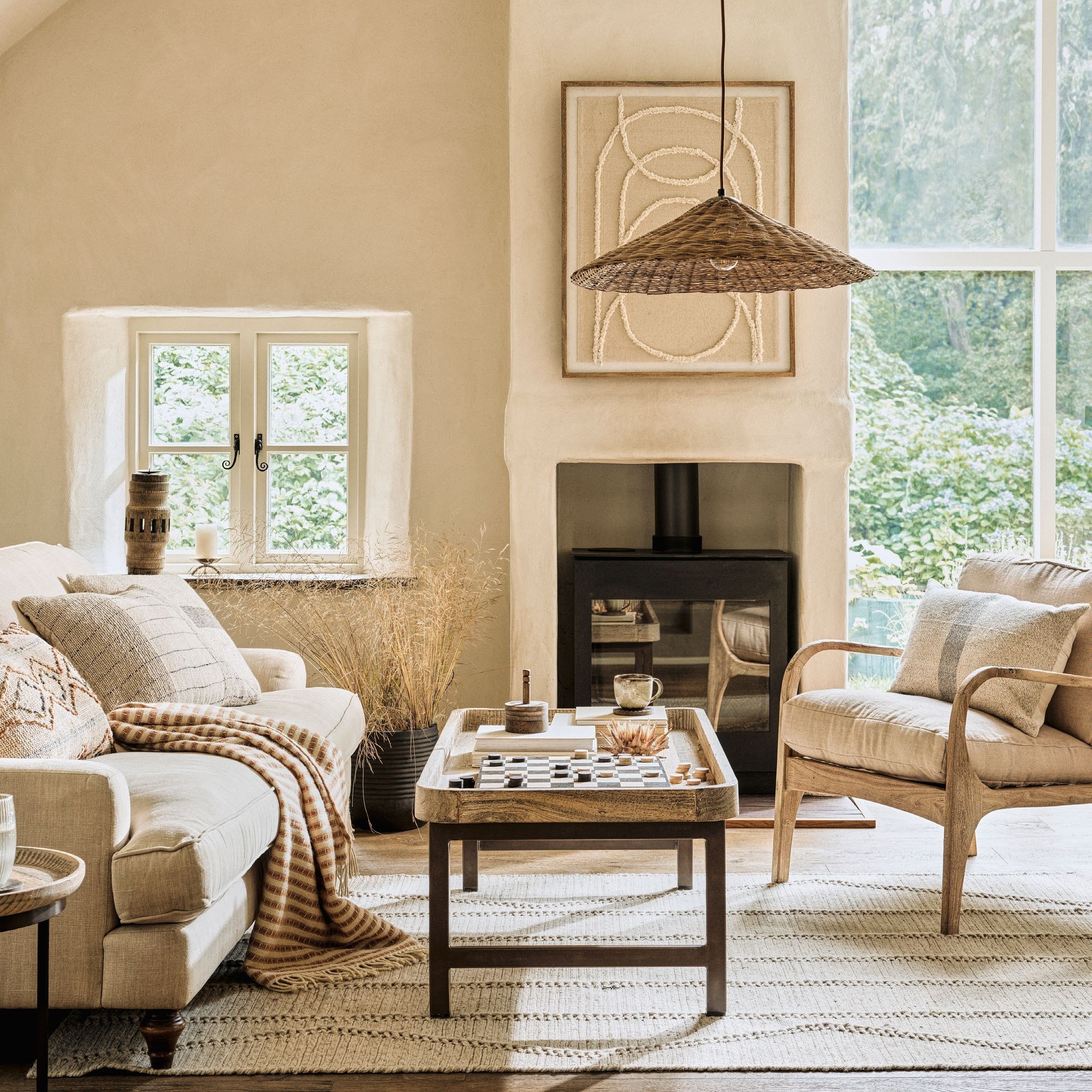 Cream living room with white sofa and armchair, coffee table and lamp shade