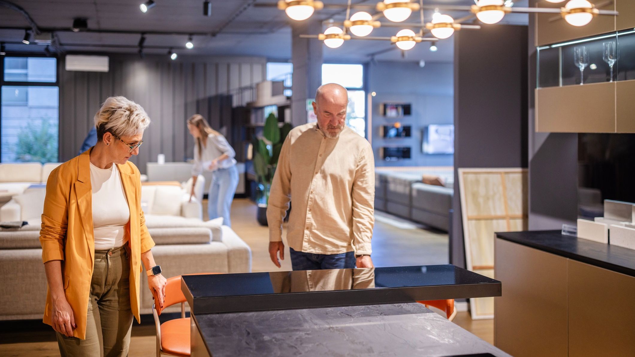 An older couple considers kitchen cabinets and counters at a design store.