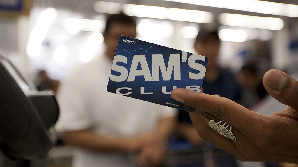A cashier handing a customer their Sam's Club card