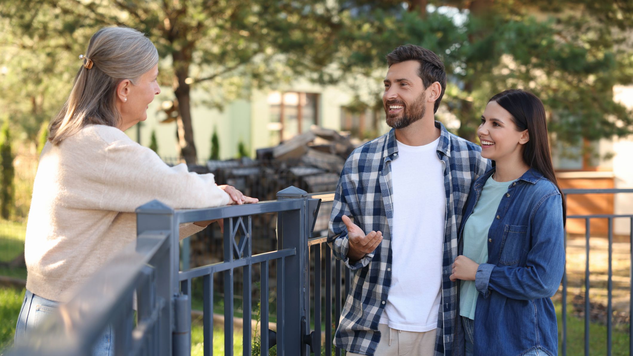 Neighbors talking, standing near a fence